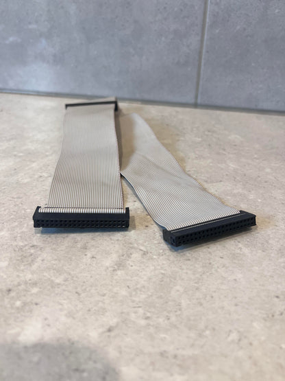 Close-up of both ends of 40-pin IDC ribbon cable with black connectors