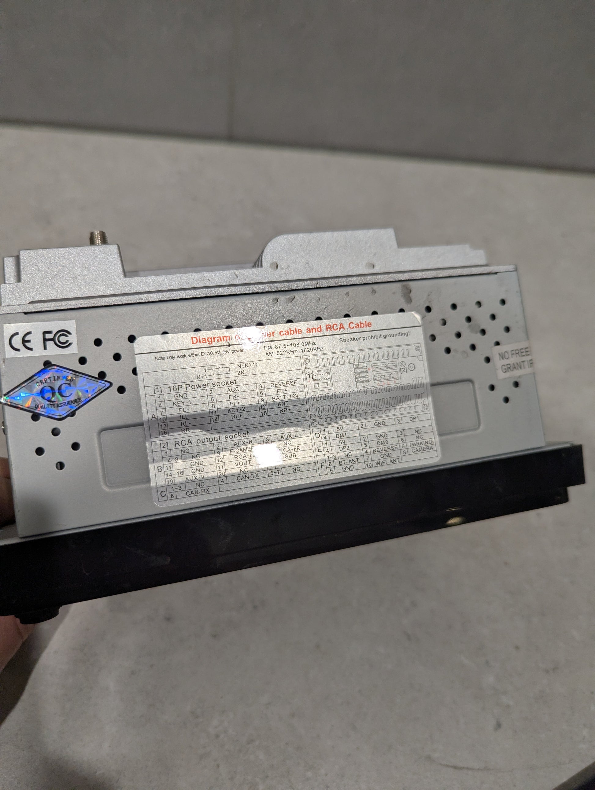 Close-up of car stereo head unit's wiring diagram and certification labels