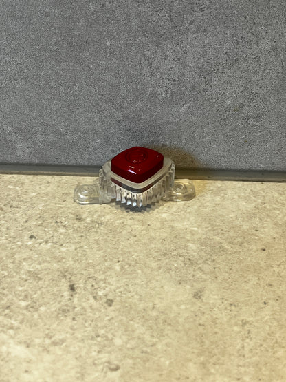 Single red mechanical keyboard keycap mounted in a transparent base