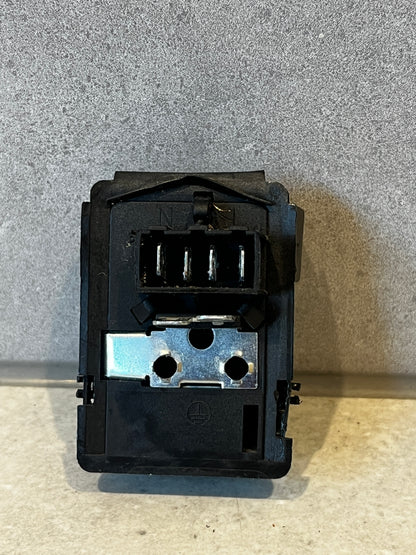 Rear view of black electrical relay switch showing metal connectors and terminal slots