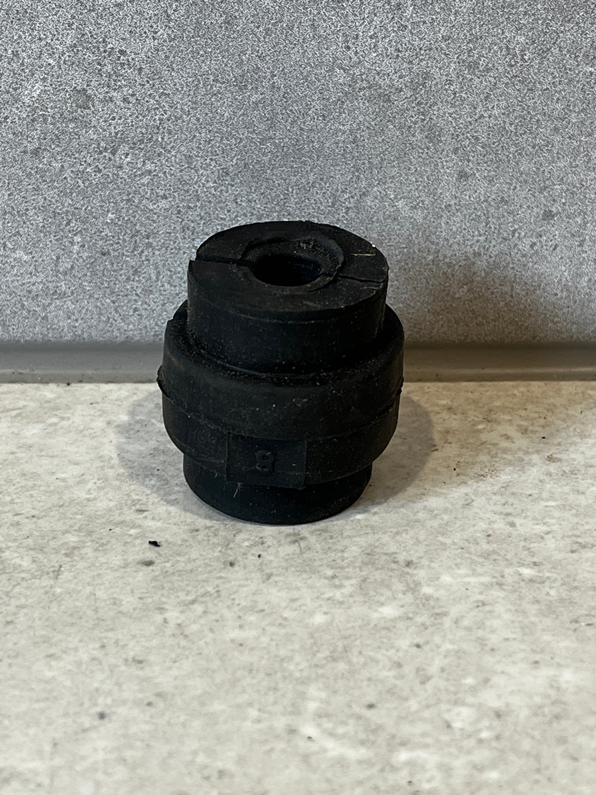 Single black rubber bush from Armada 28mm kit displayed upright