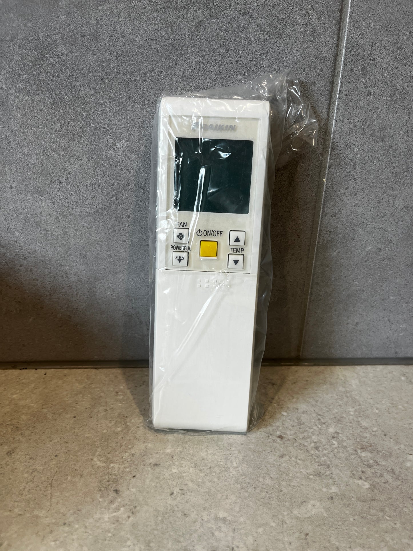 Close-up of Daikin remote controller assembly in protective plastic wrap