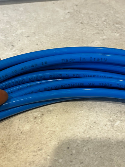 Close-up of blue polyurethane tubing with 'Made in Italy' and specifications printed