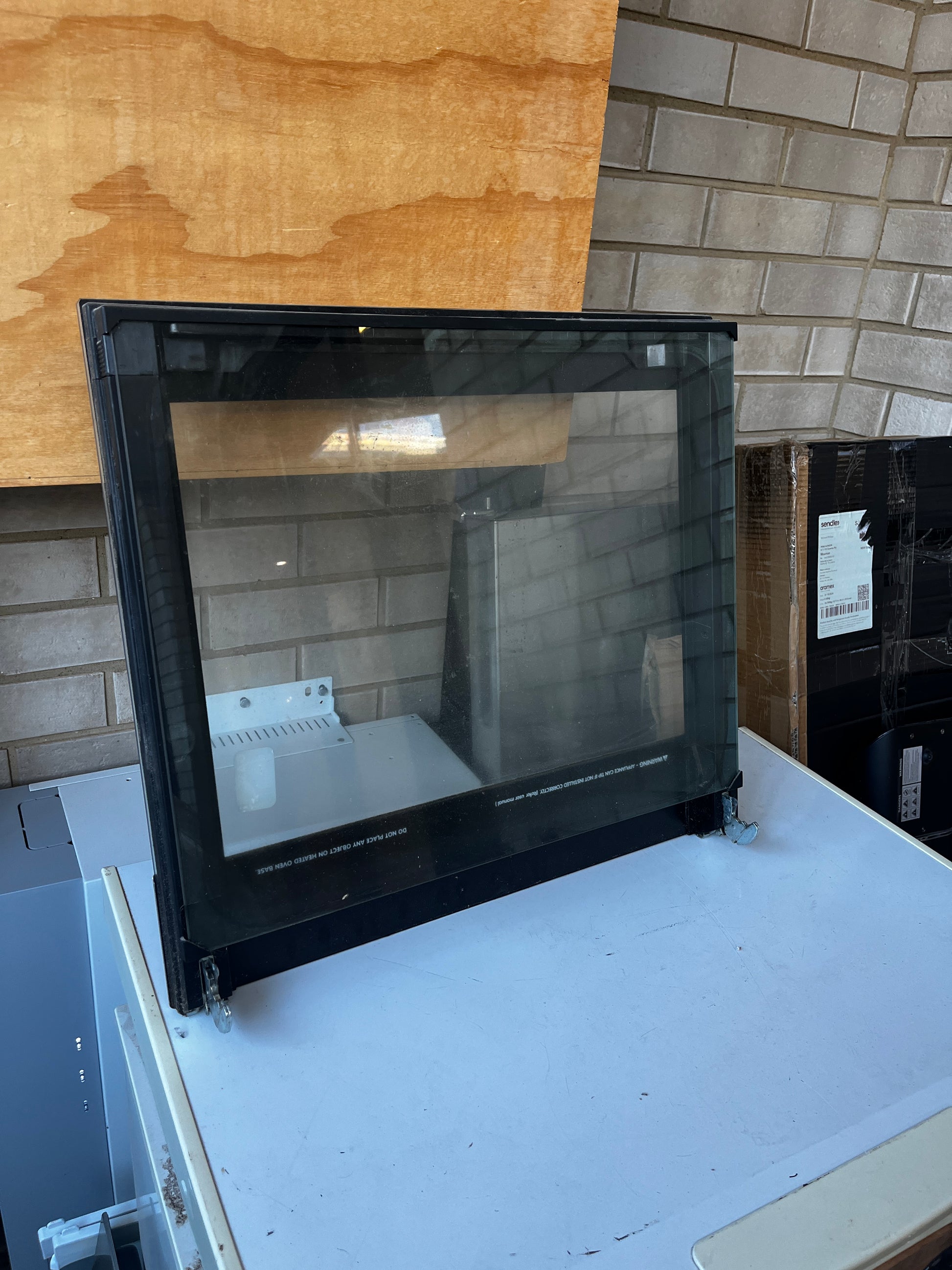 Side angle view of Chef oven door showing black frame and mounting brackets