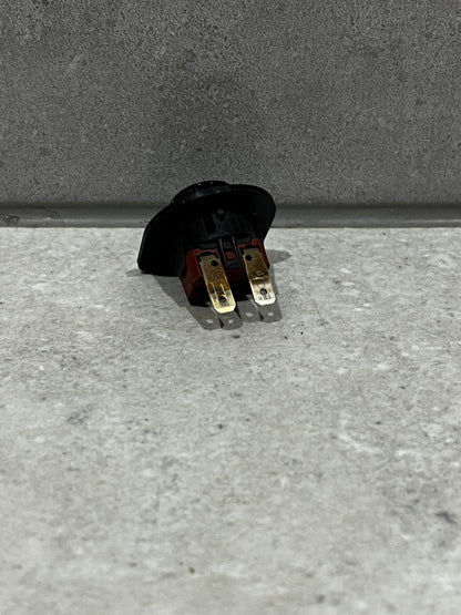 Rear view of round rocker switch showing two metal prongs