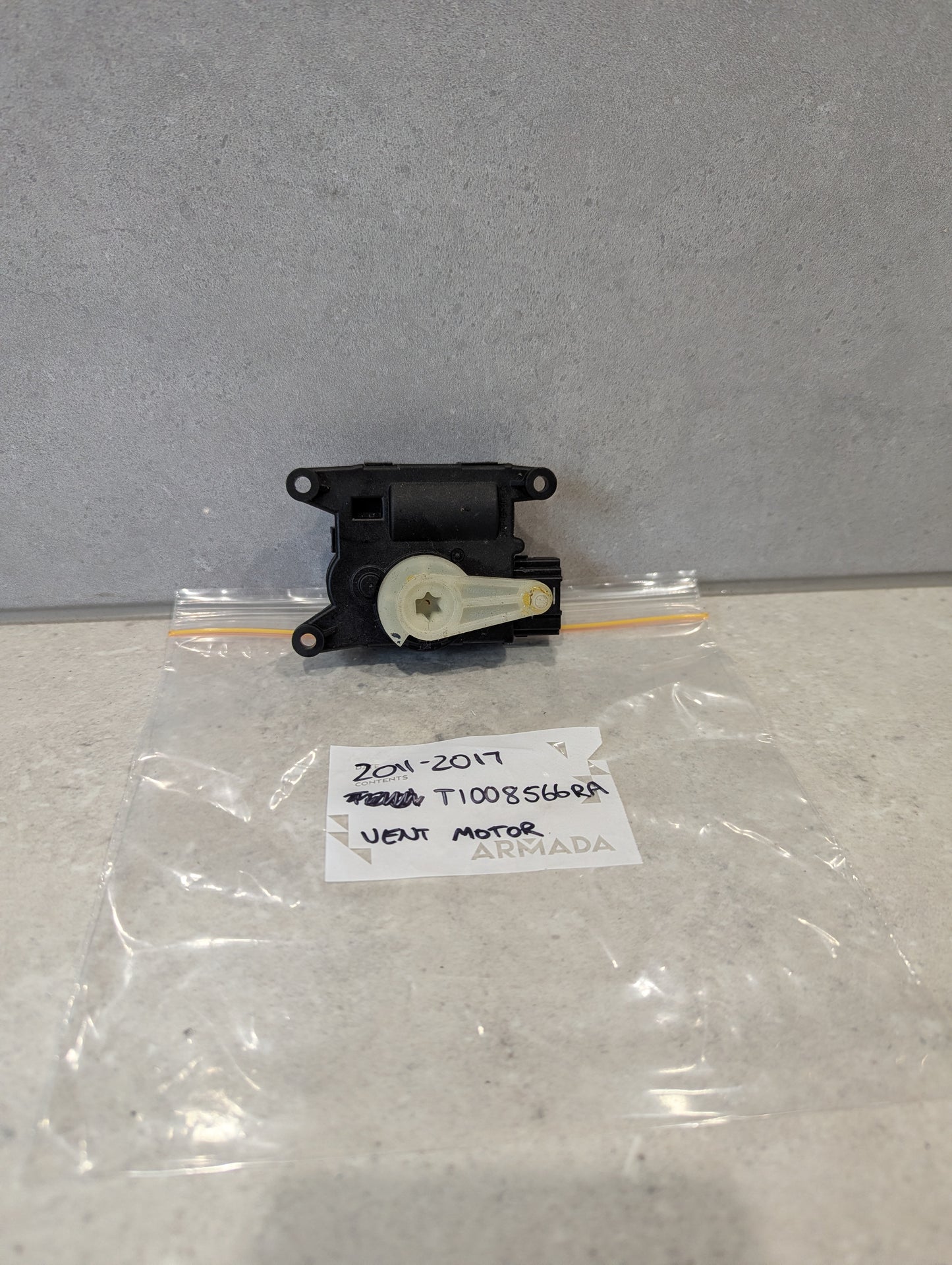 Rear view of Nissan heater vent flap control actuator showing attachment points for Nissan models