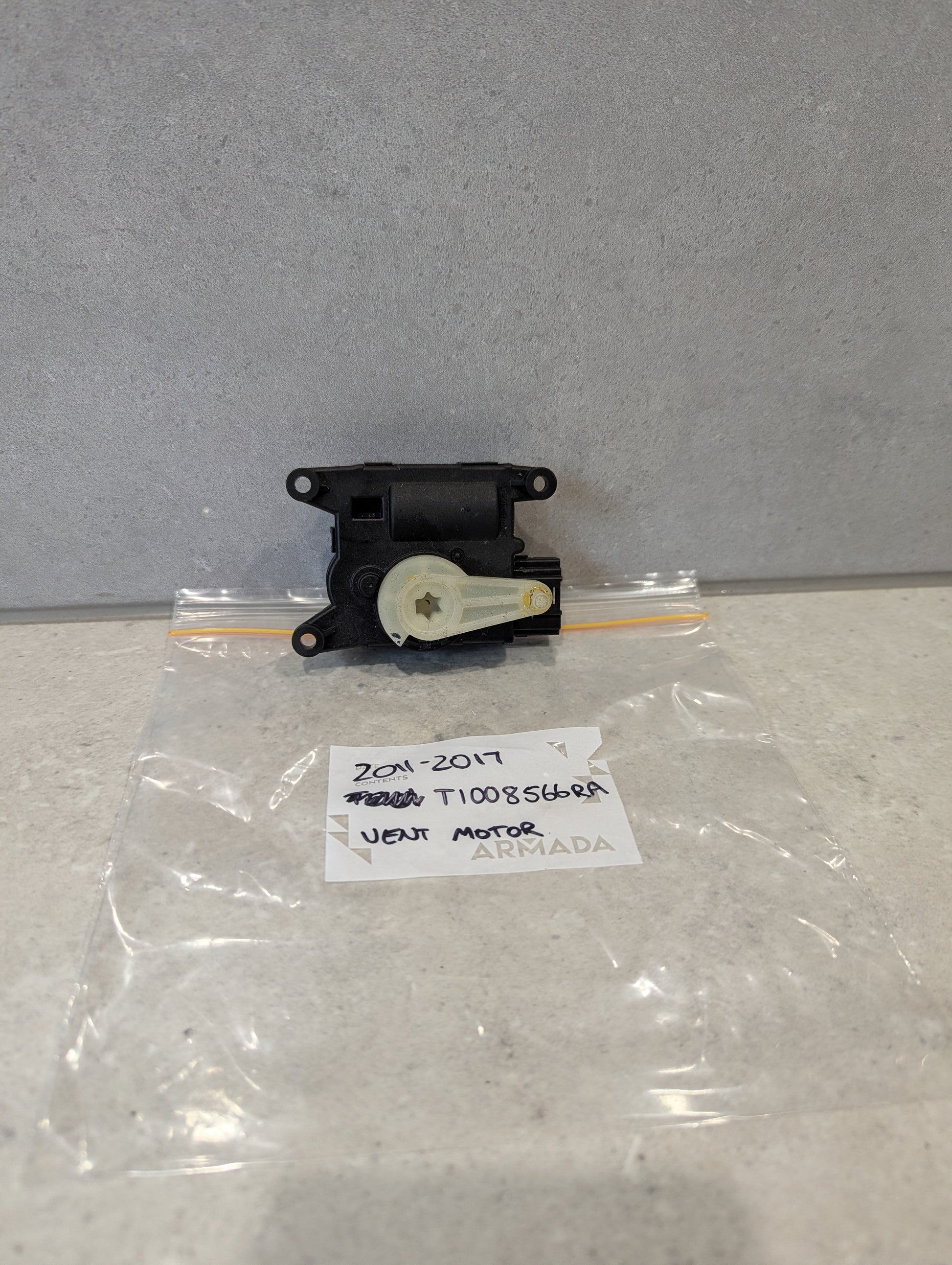 Rear view of Nissan heater vent flap control actuator showing attachment points for Nissan models
