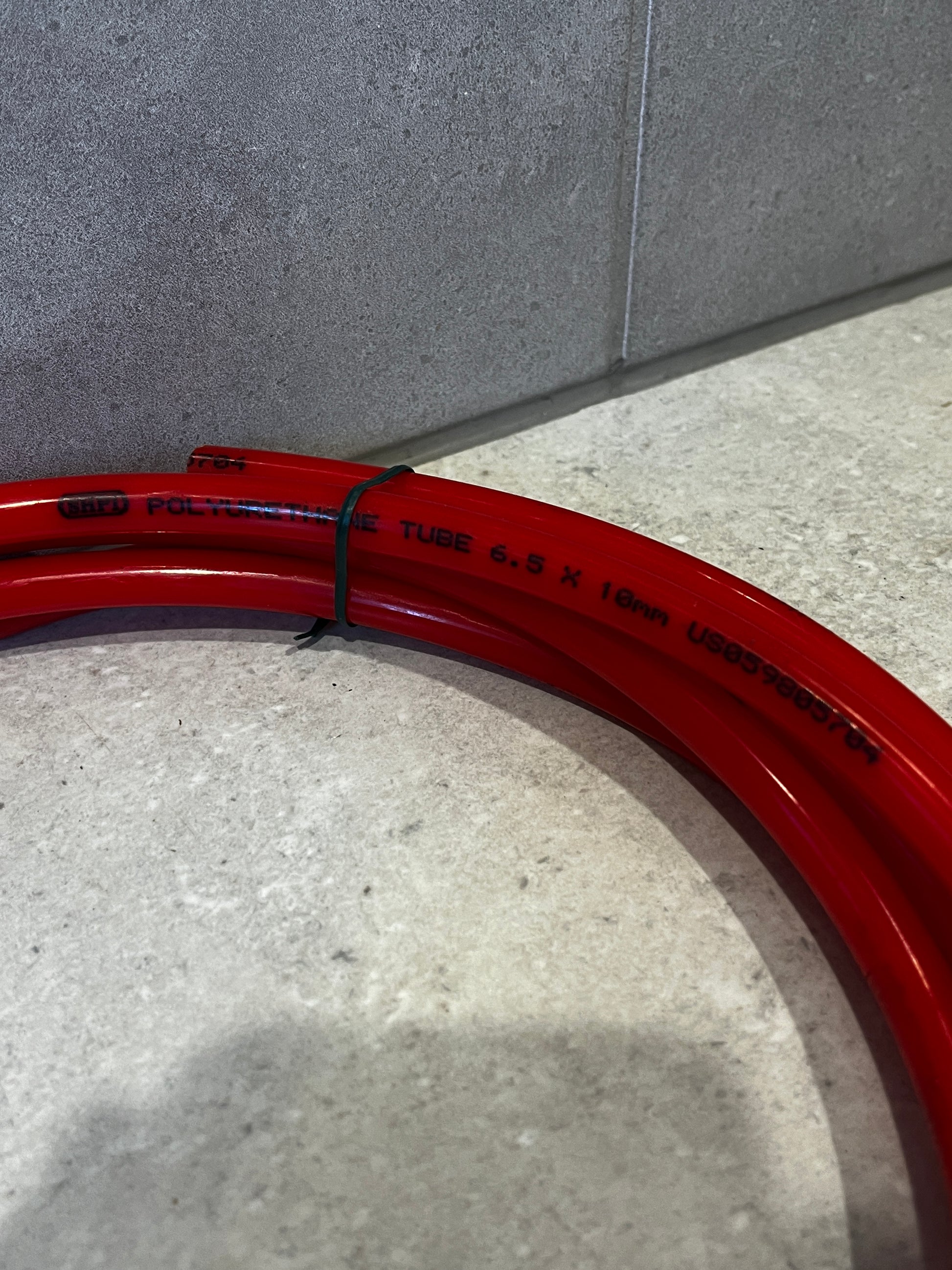 Close-up of red polyurethane tube hose showing size and material details