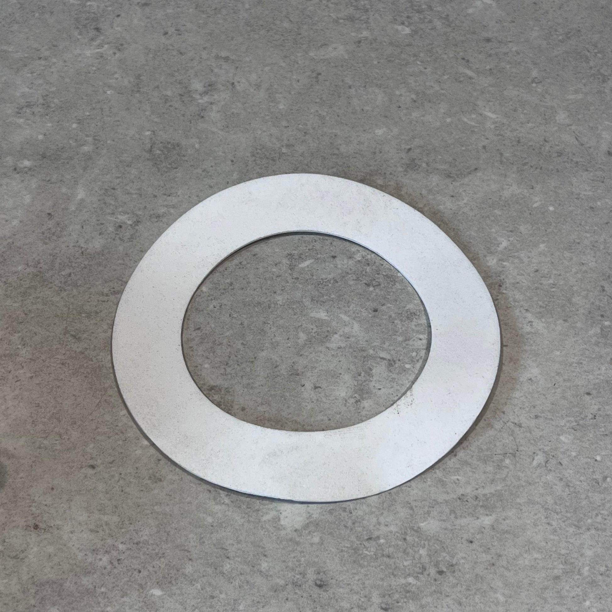 Single Garlock PTFE gasket on gray surface