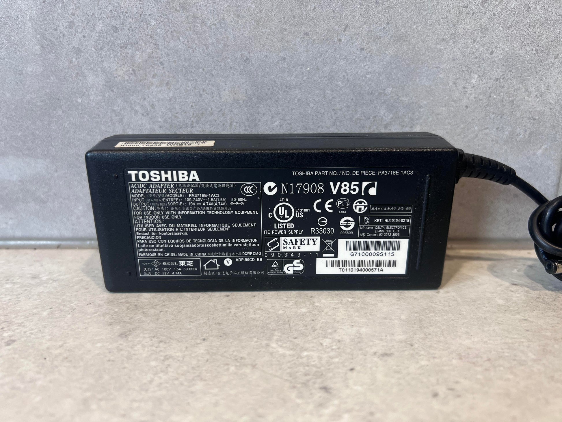 Close-up of Toshiba AC/DC adapter model PA3716E-1AC3 showing specifications