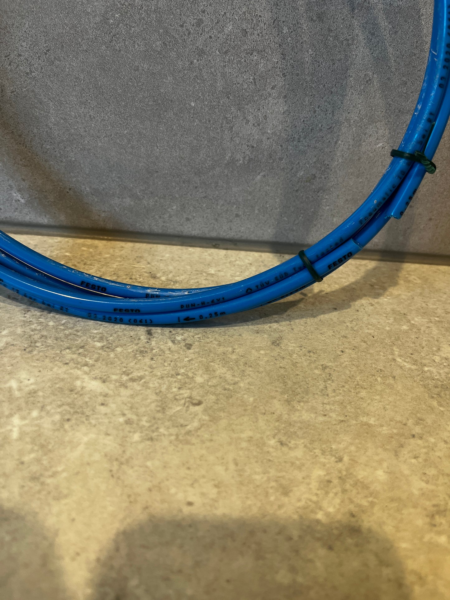 Close-up of blue pneumatic tubing coil showing printed branding and specifications