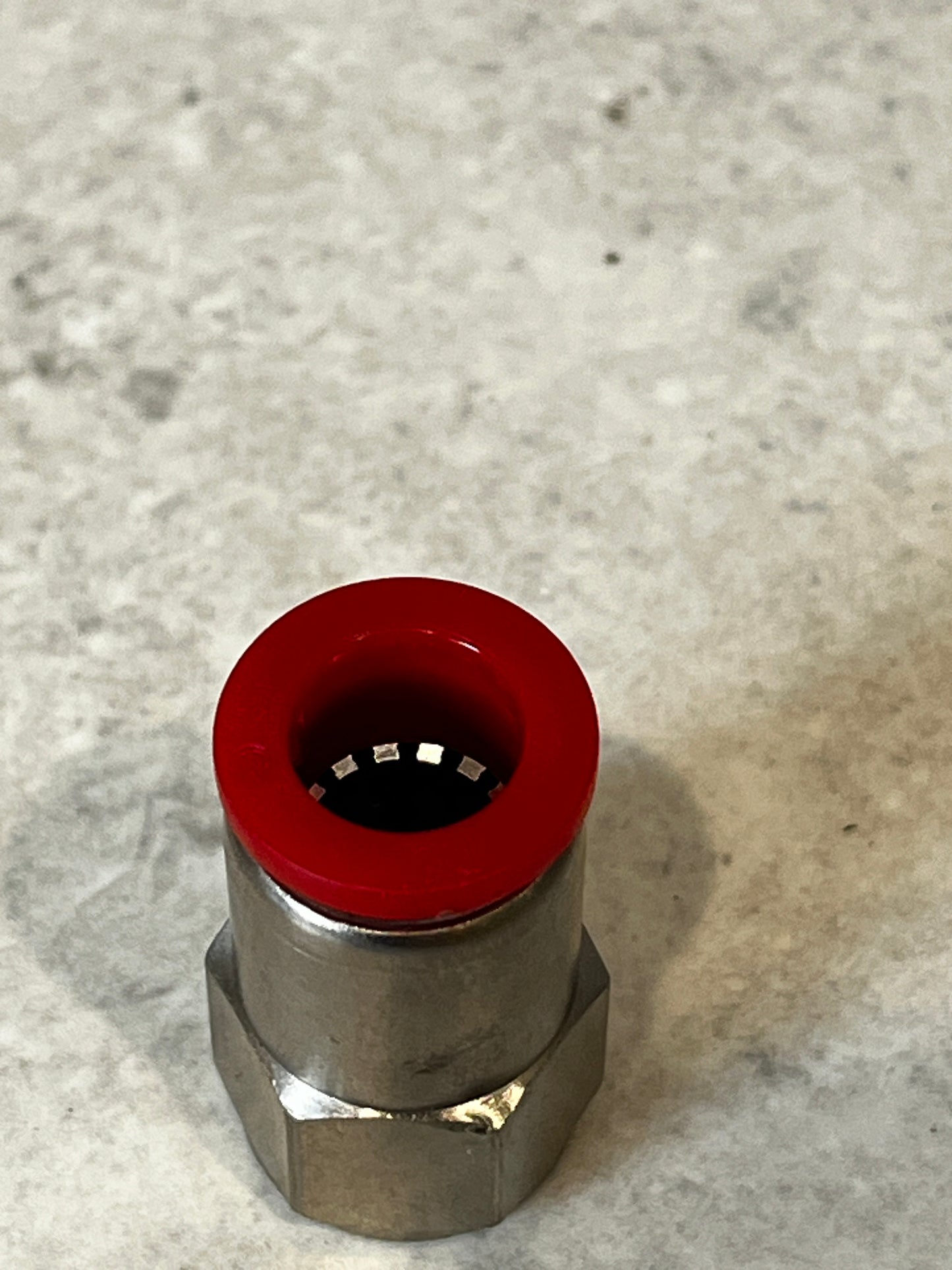 Top view of coaxial cable compression connector showing red compression ring
