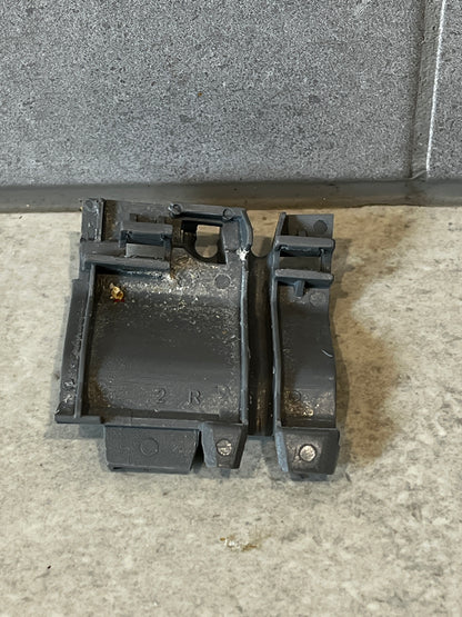 Gray plastic mechanical clip set on a light surface, rear view