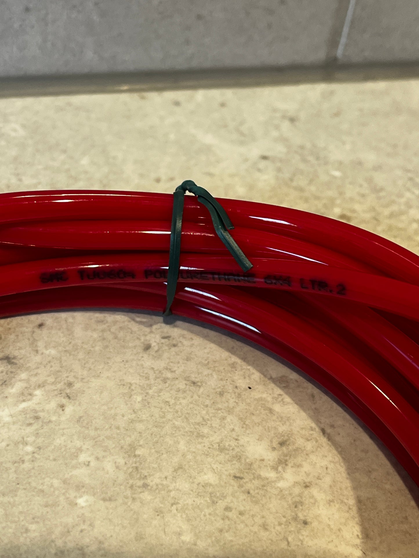 Close-up of red polyurethane tubing coil showing material text
