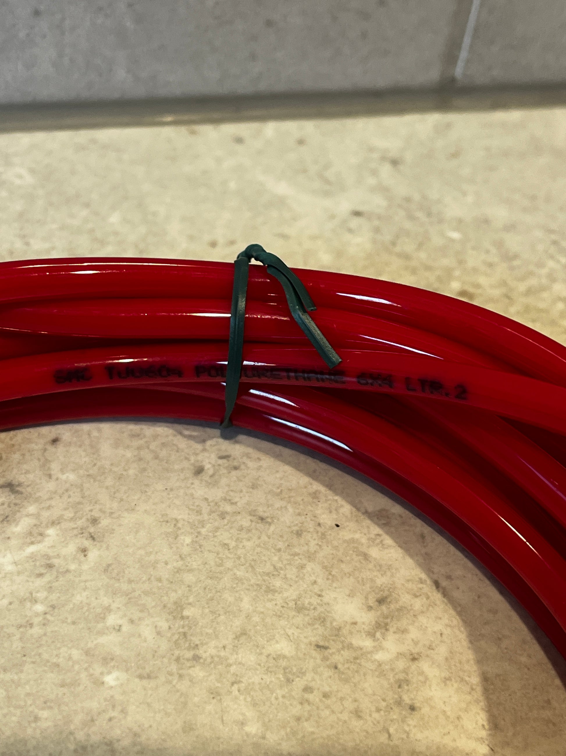 Close-up of red polyurethane tubing coil showing material text