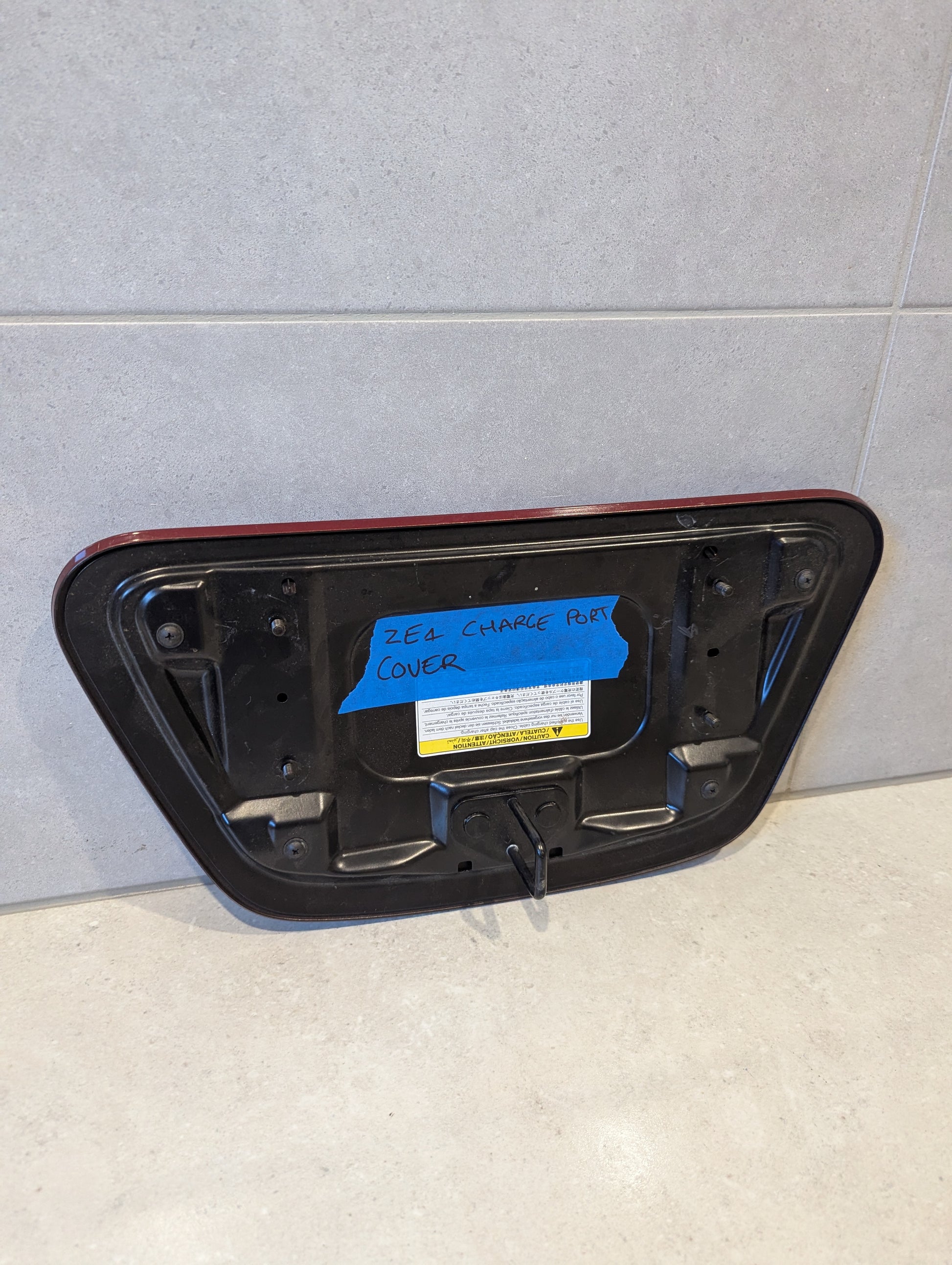 Rear view of Nissan Leaf ZE1 charge port cover showing mounting points
