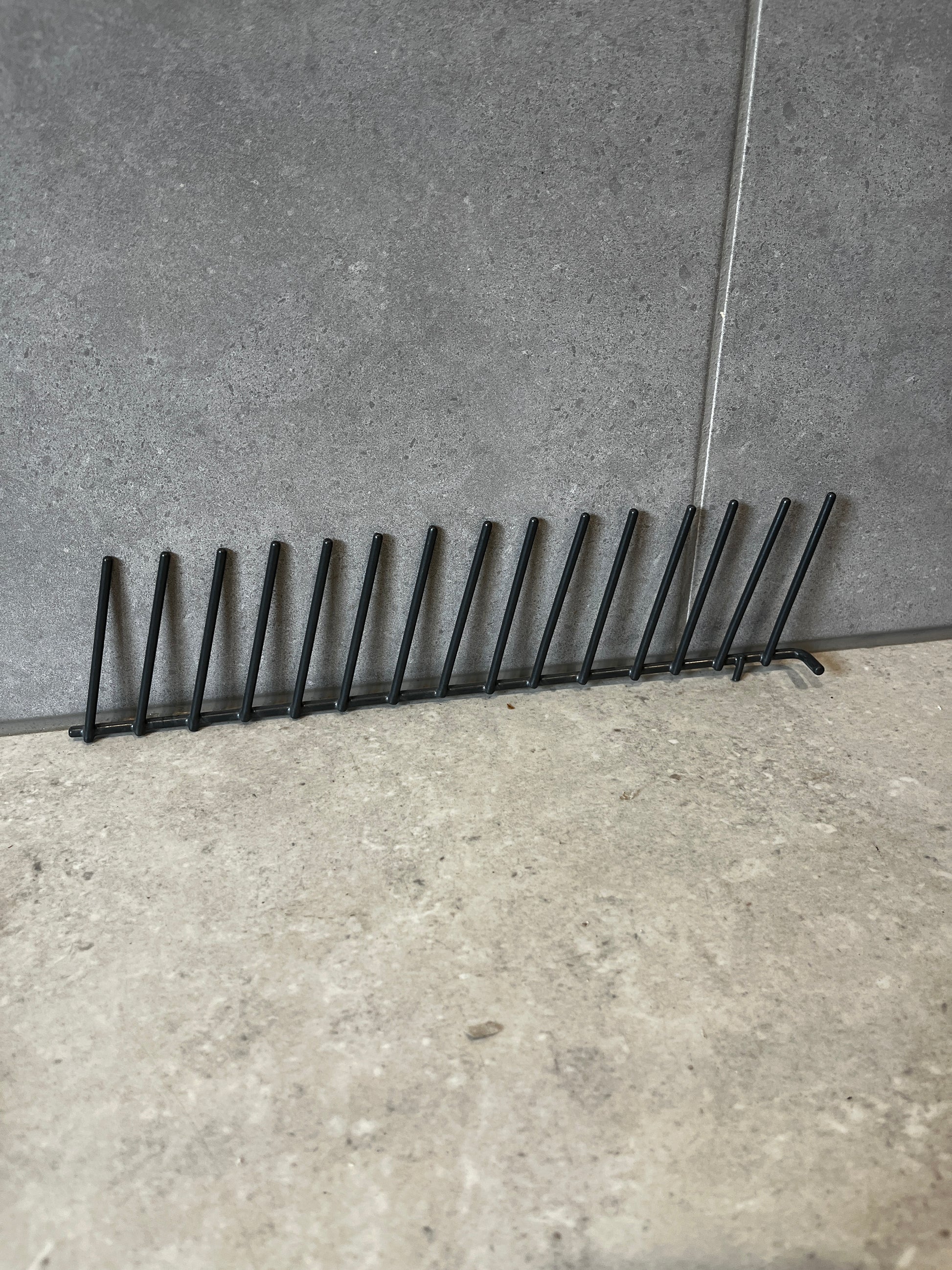 Side view of black metal vertical plate rack for kitchen organization