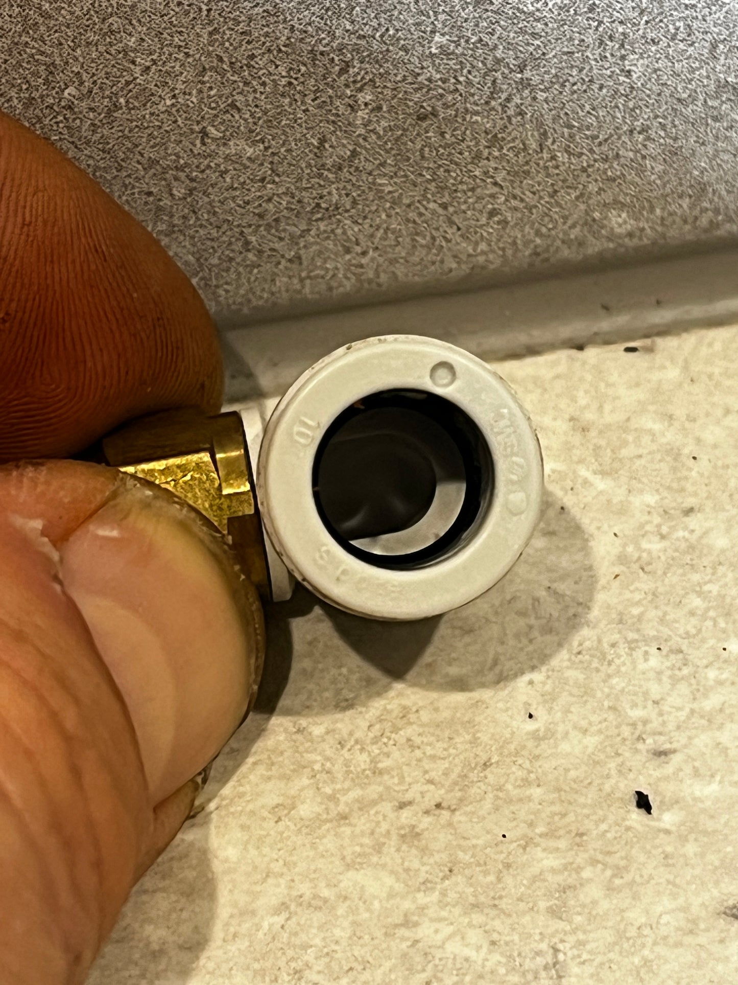 Close-up of push-to-connect elbow fitting showing internal opening