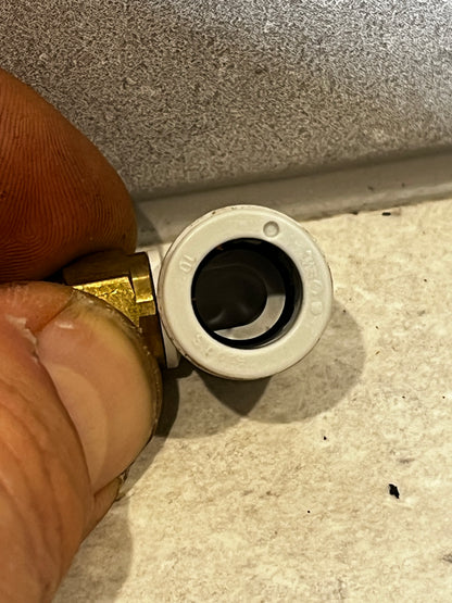 Close-up of push-to-connect elbow fitting showing internal opening