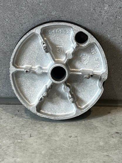 Bottom view of a round cast metal end cap showing structural details and technical markings