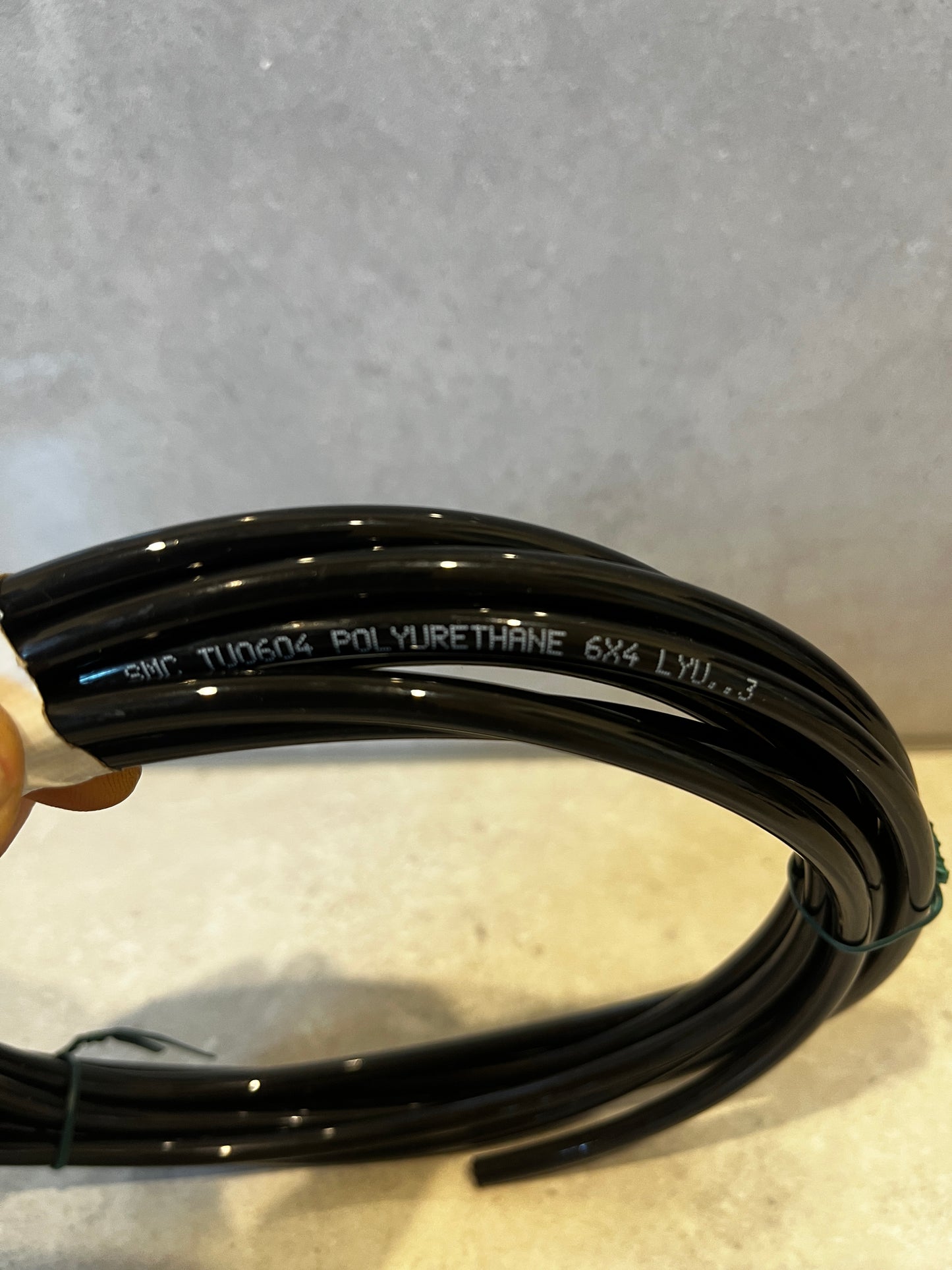 Close-up of black polyurethane tubing with manufacturing details printed on it