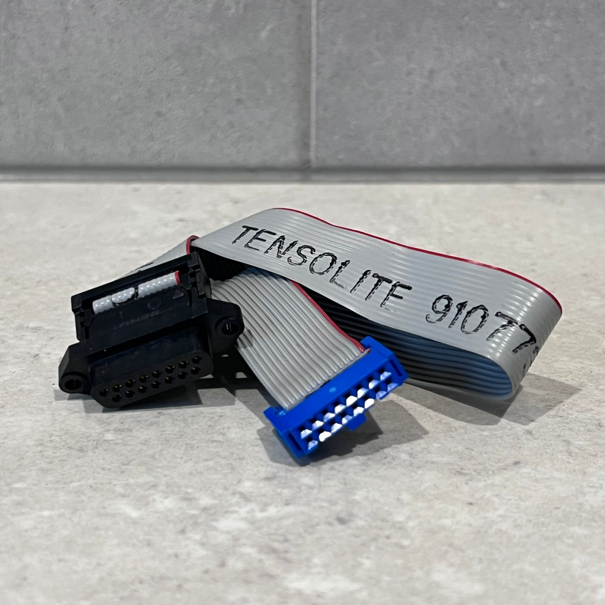 Close-up of TENSOLITE IDC flat 16 pin TODB15 cable showing connectors and printed text