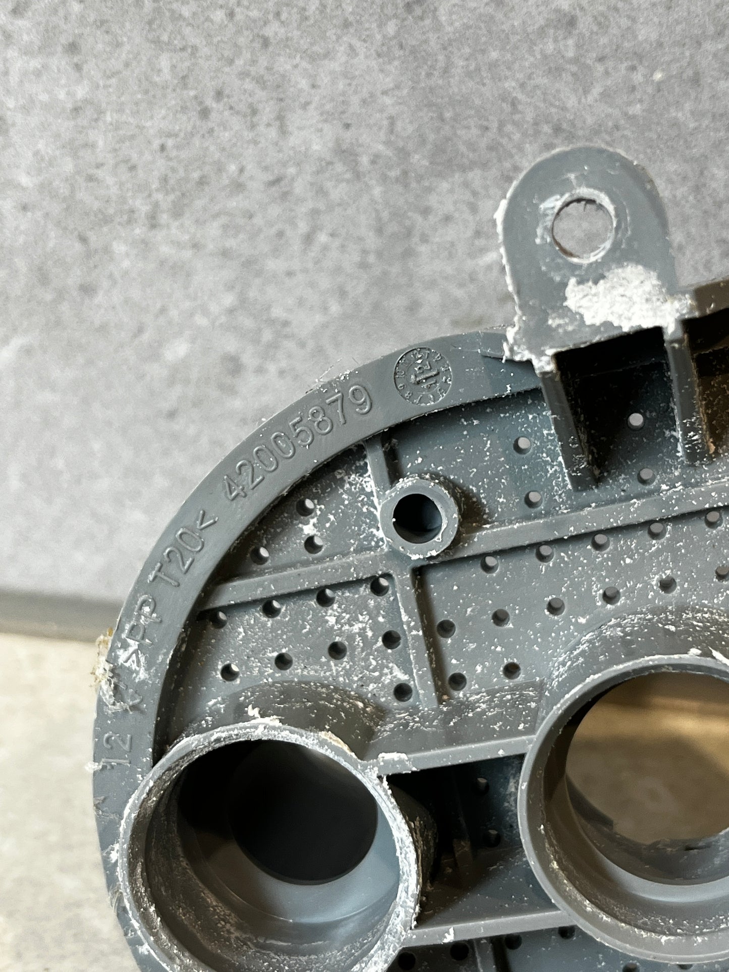Close-up of model number and circular ports on the washer pump housing part