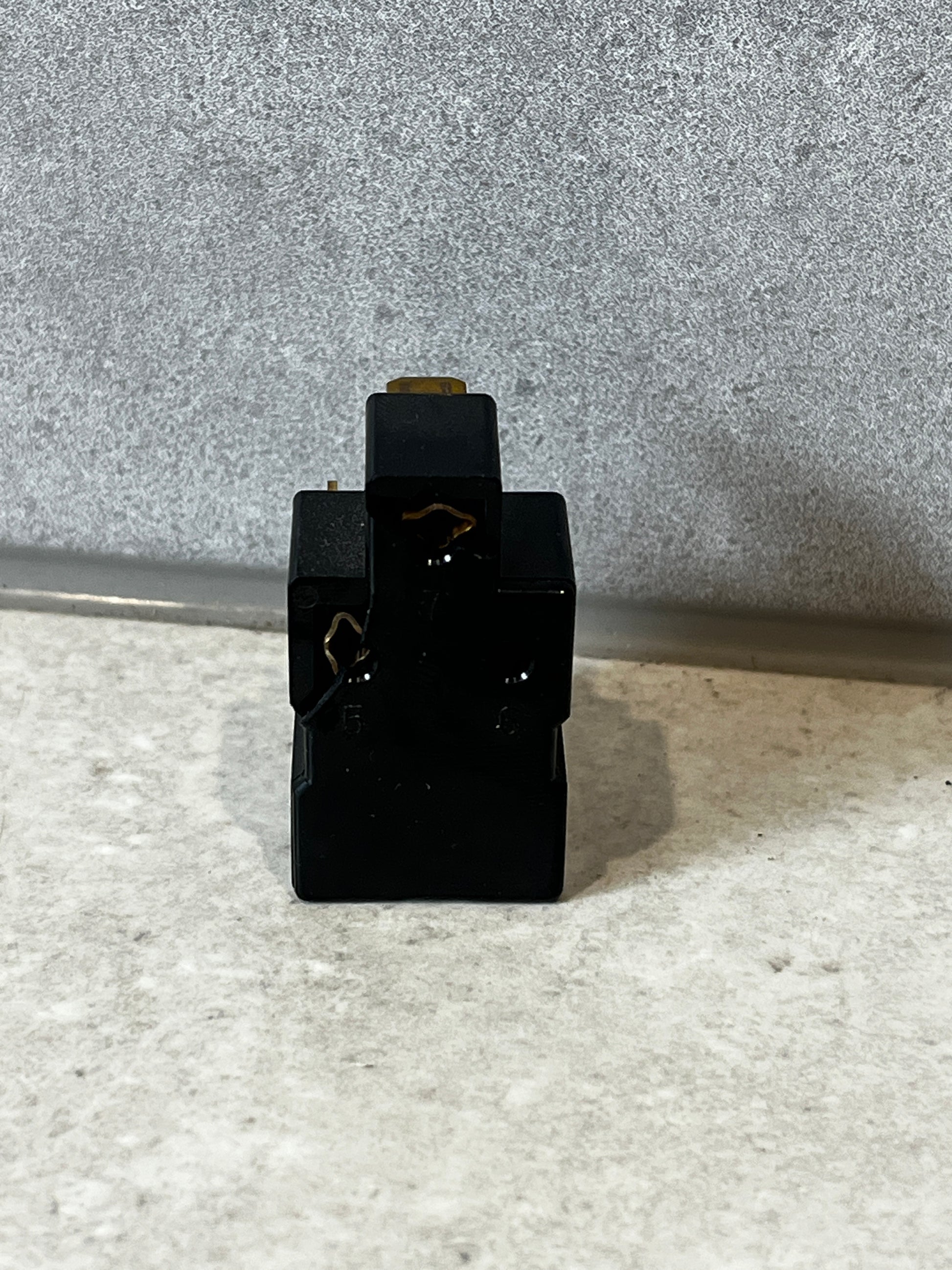 Rear view of black electrical relay switch showing terminals