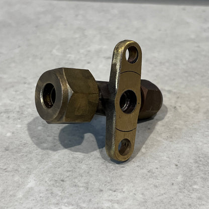 Close up of brass 3-way service valve showing fittings and mounting holes