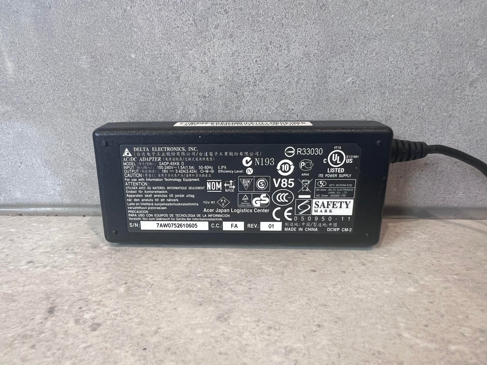 Close-up of Delta Electronics AC/DC adapter label with specifications