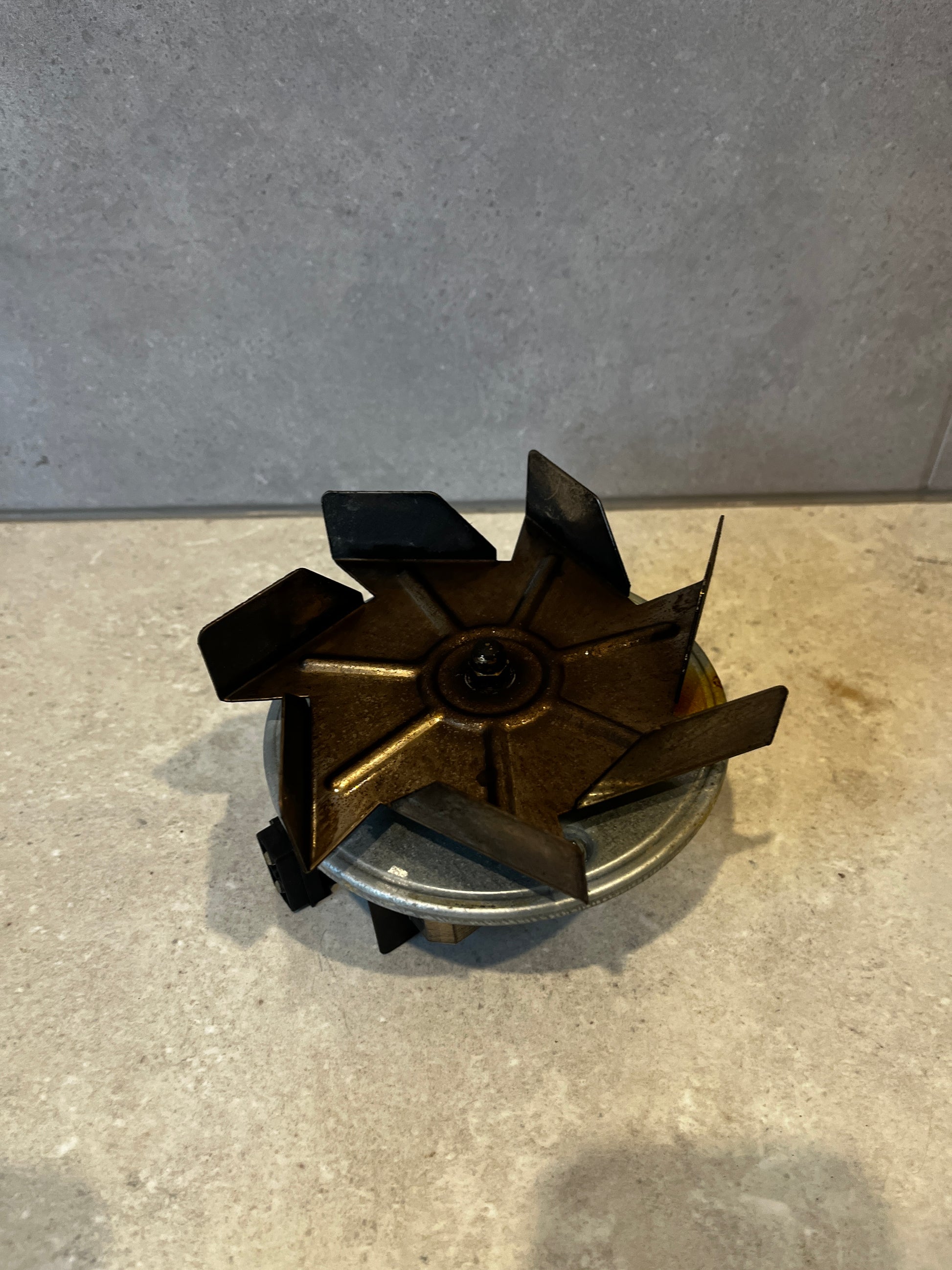 Top view of electric fan motor assembly showing angled metal blades