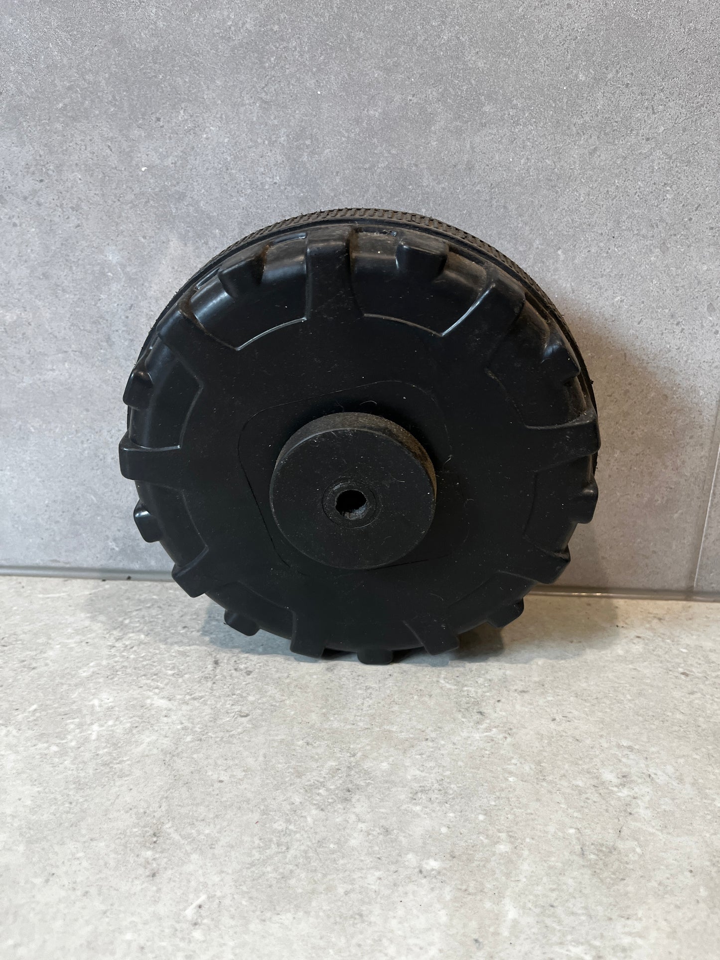 Rear view of sturdy black replacement wheel for utility wagon