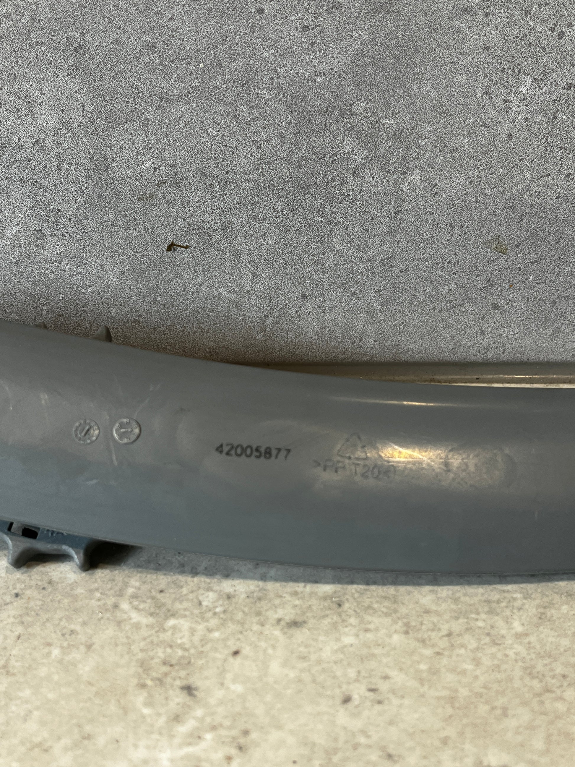 Close-up of grey plastic part showing product code and markings
