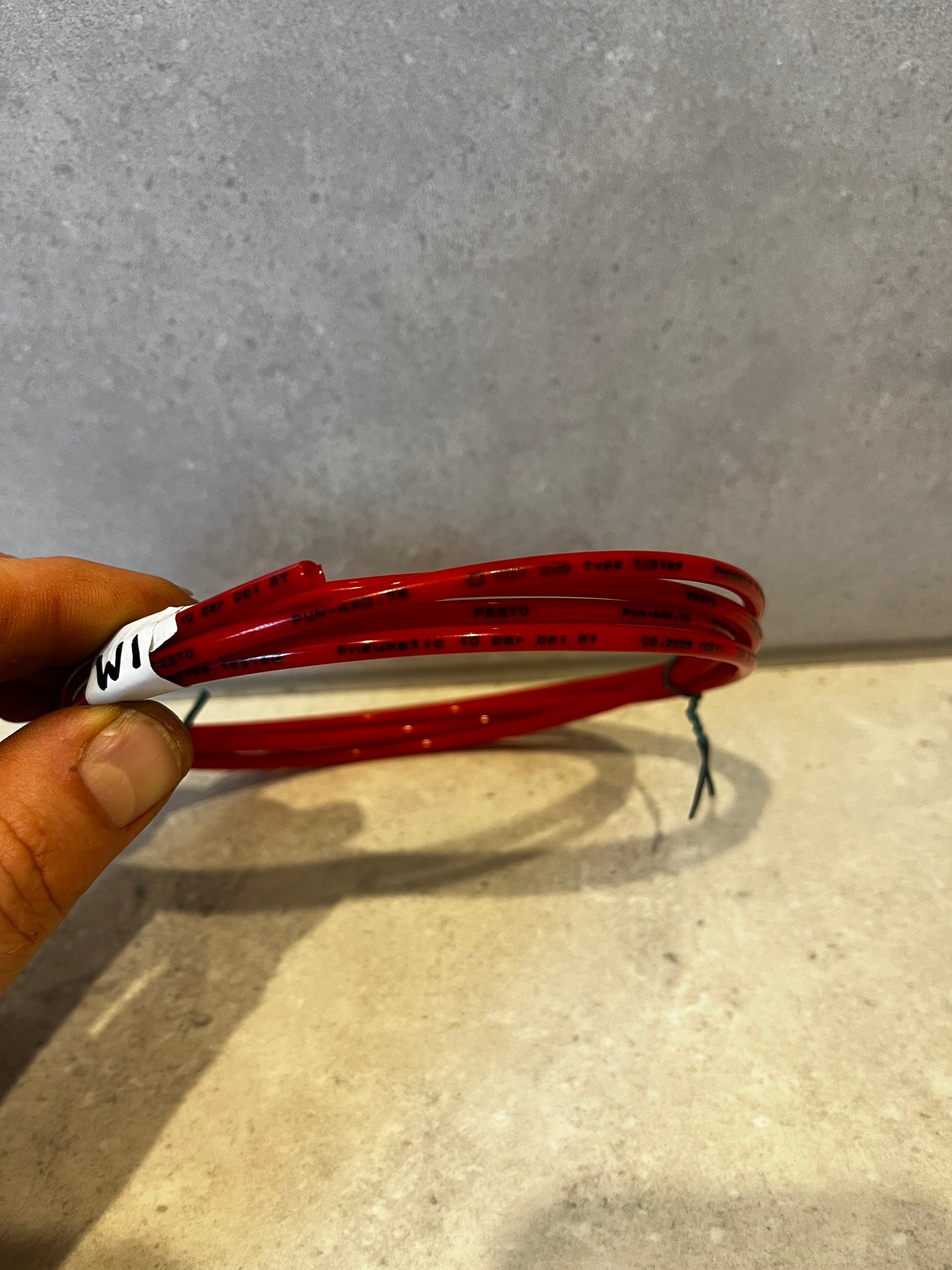Close-up side view showing pressure and brand markings on red pneumatic tubing
