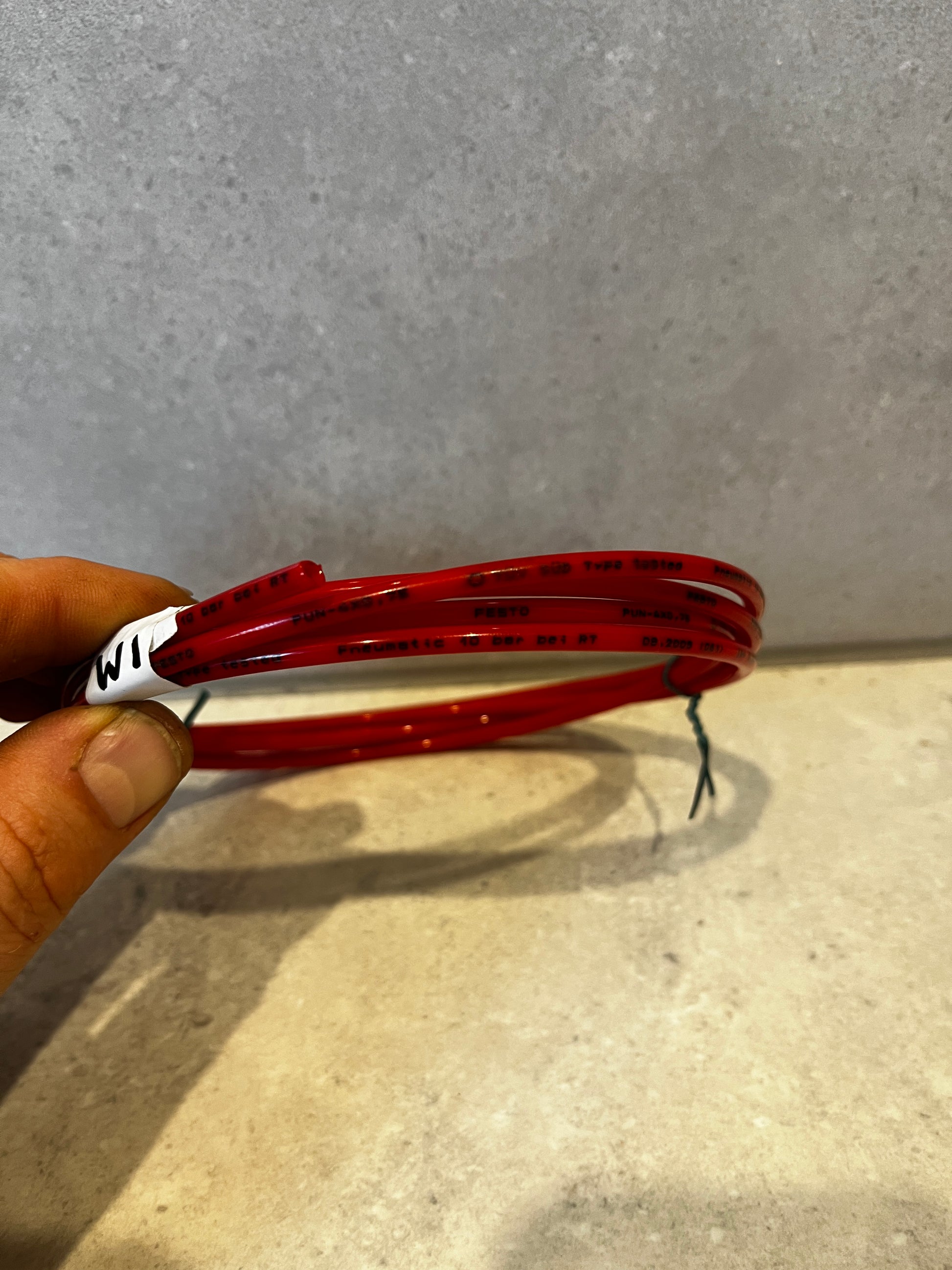 Close-up side view showing pressure and brand markings on red pneumatic tubing