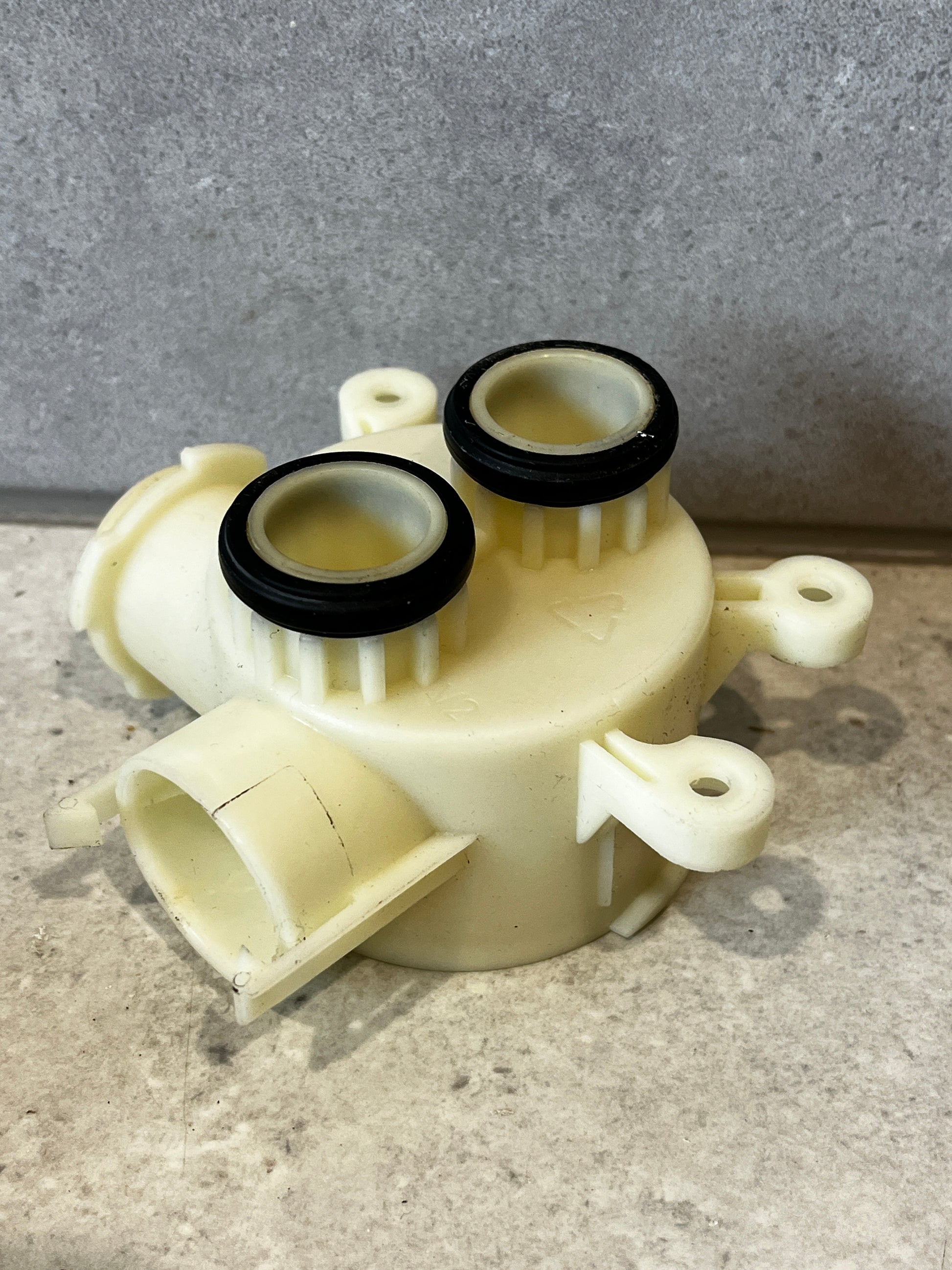 Top view of plastic water pump housing showing two O-ring sealed ports