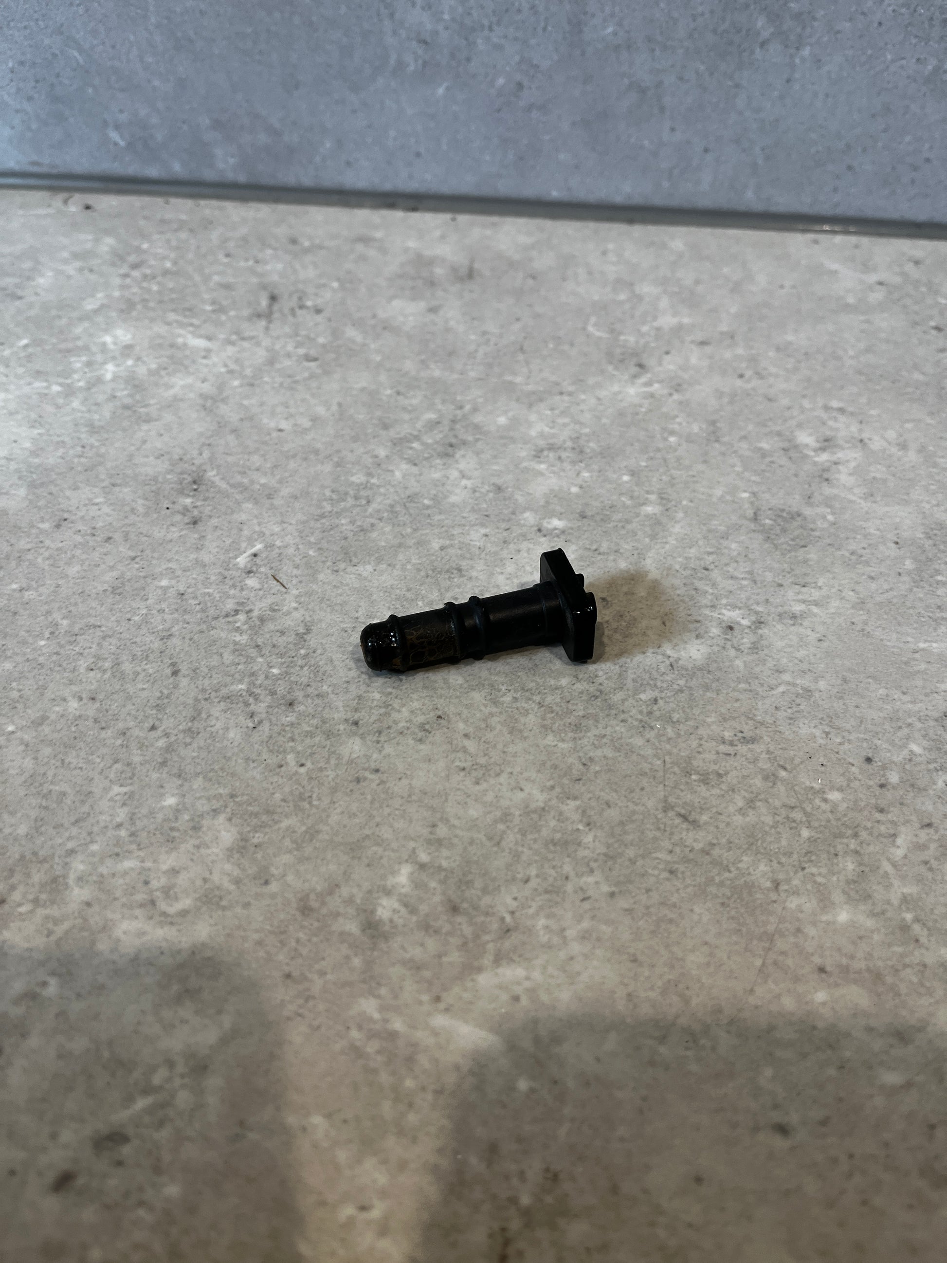 Black automotive injector valve on a countertop