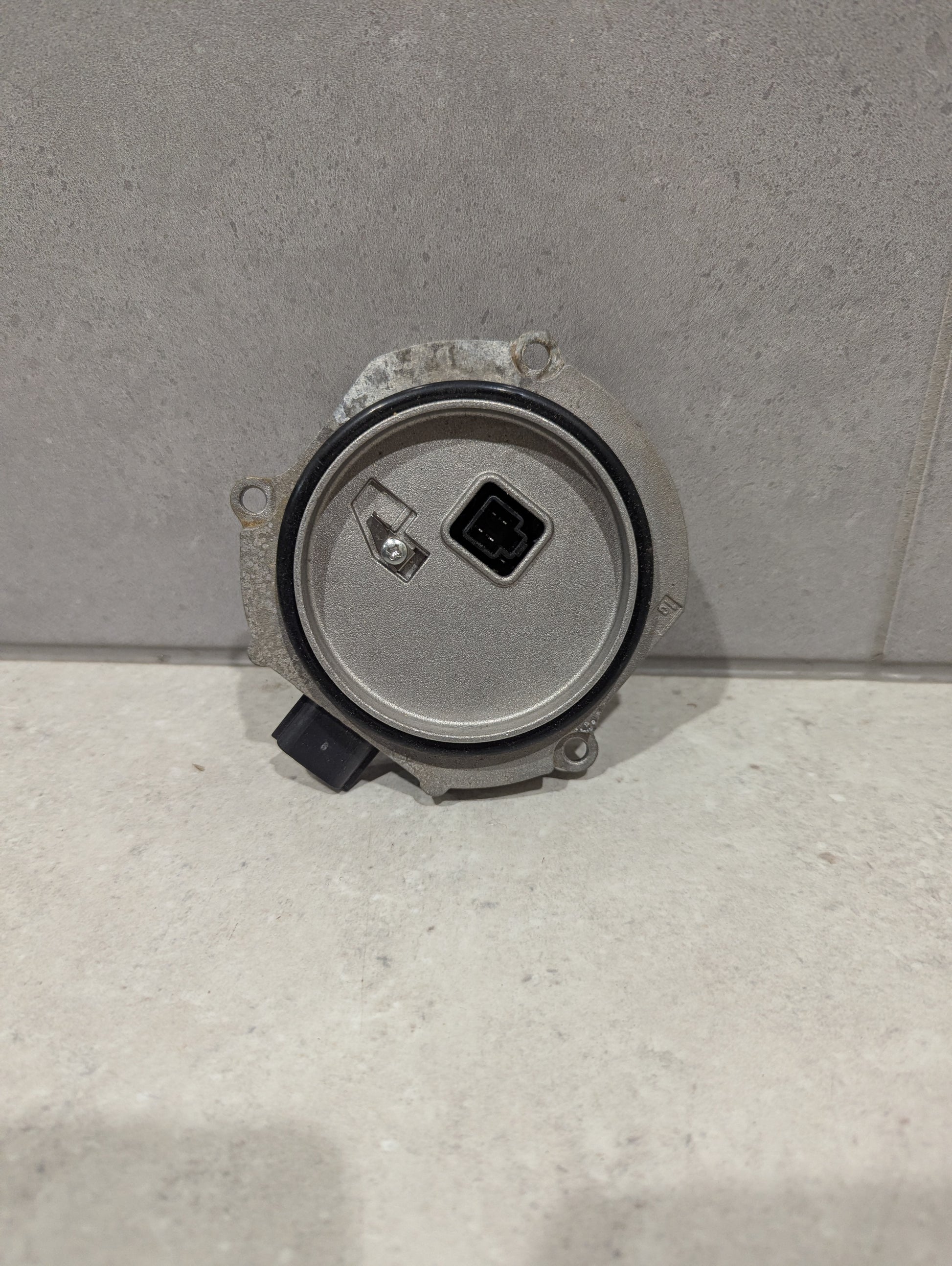 Back view of Ichikoh LED headlight control module showing circular housing and connector
