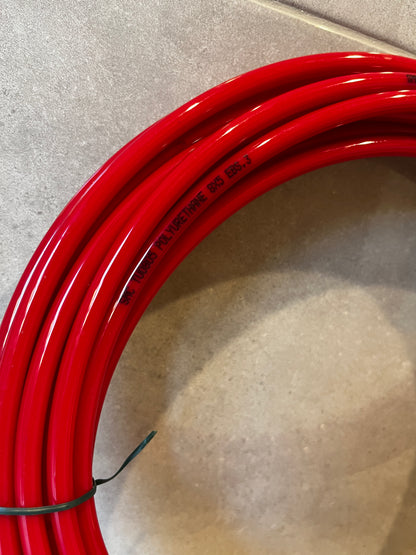 Close-up of red polyurethane tubing showing glossy finish and printed material details