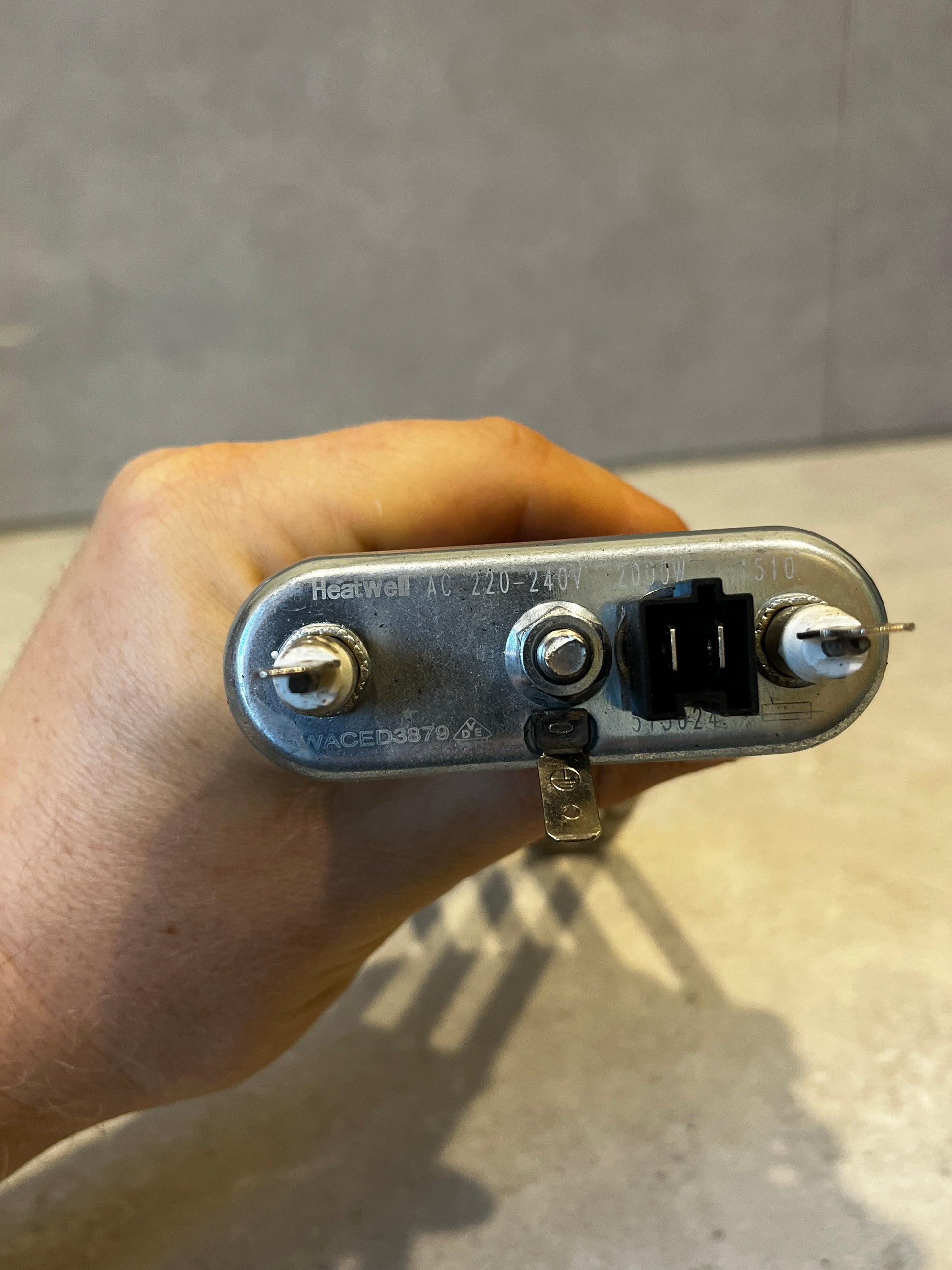 Close-up of water heater element terminal panel with voltage and wattage details