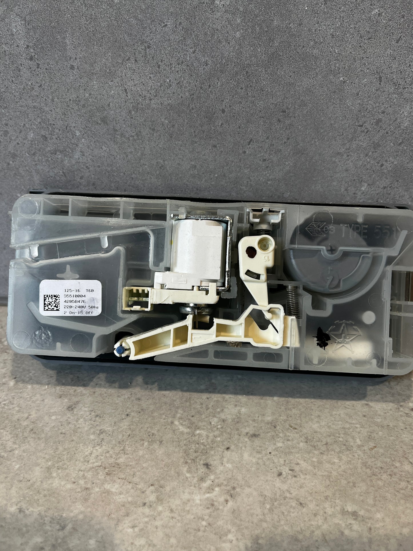 Back view of dishwasher detergent dispenser assembly showing internal components