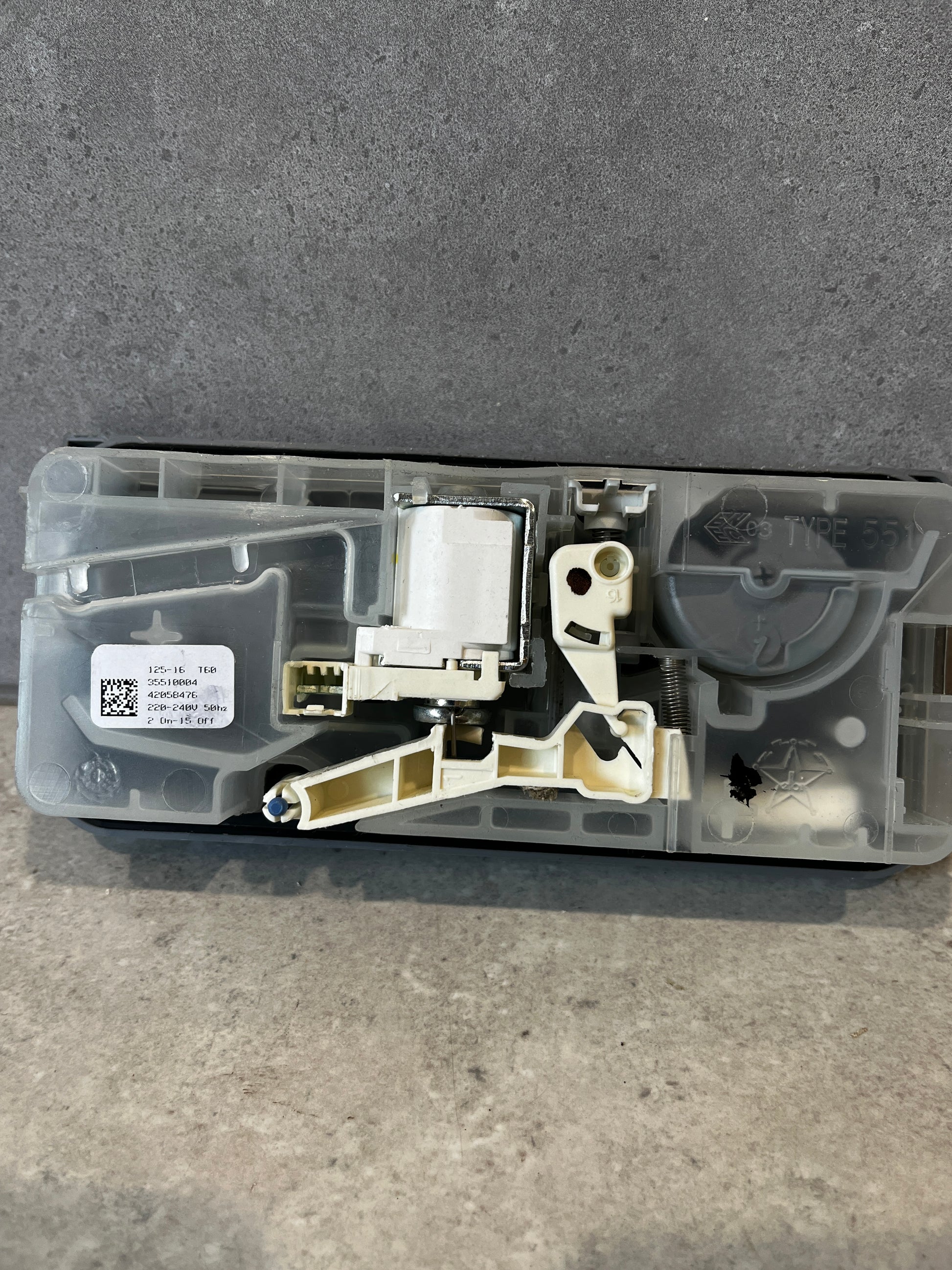 Back view of dishwasher detergent dispenser assembly showing internal components