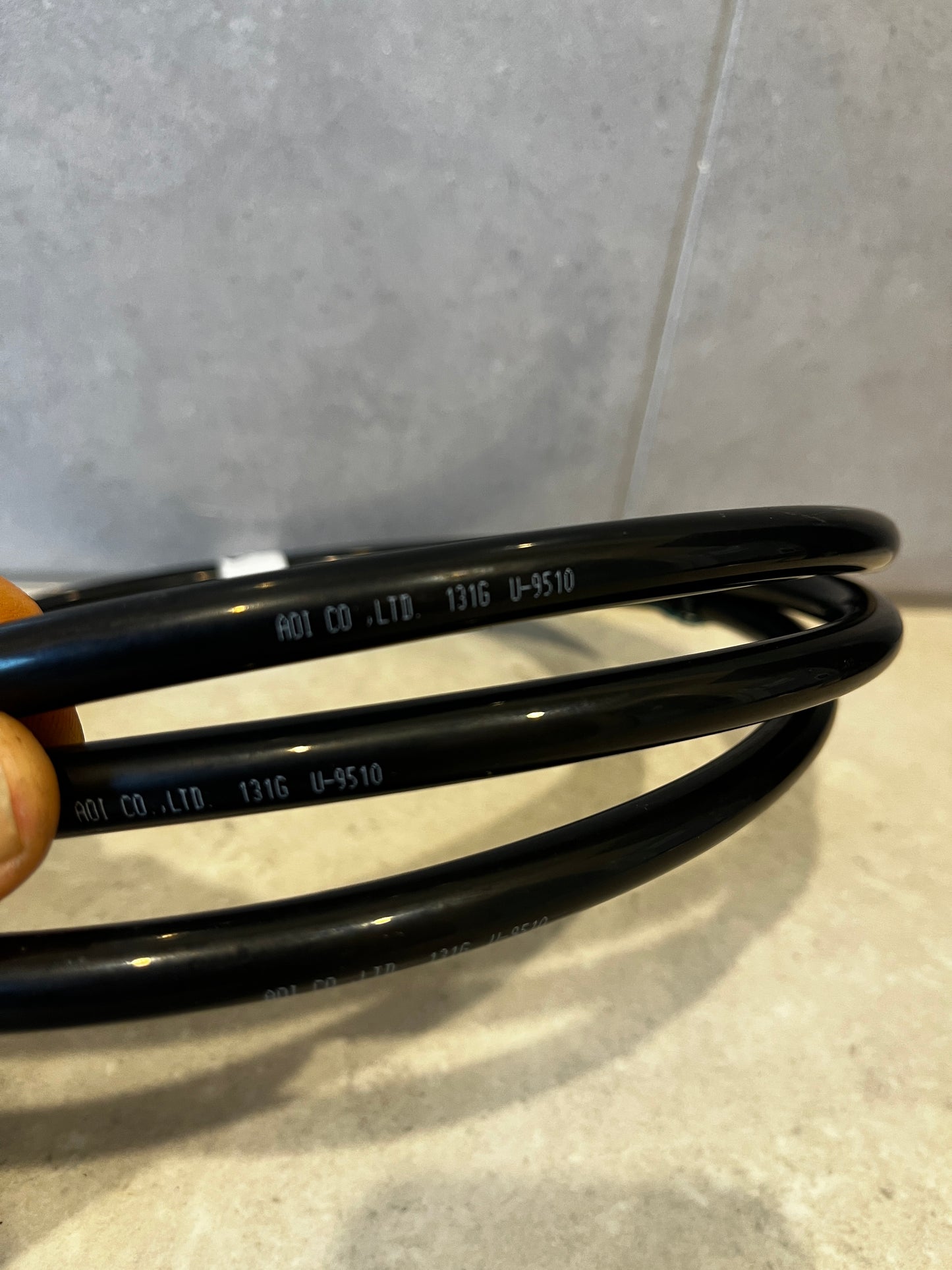 Close-up of black flexible tubing showing AOI CO. LTD branding