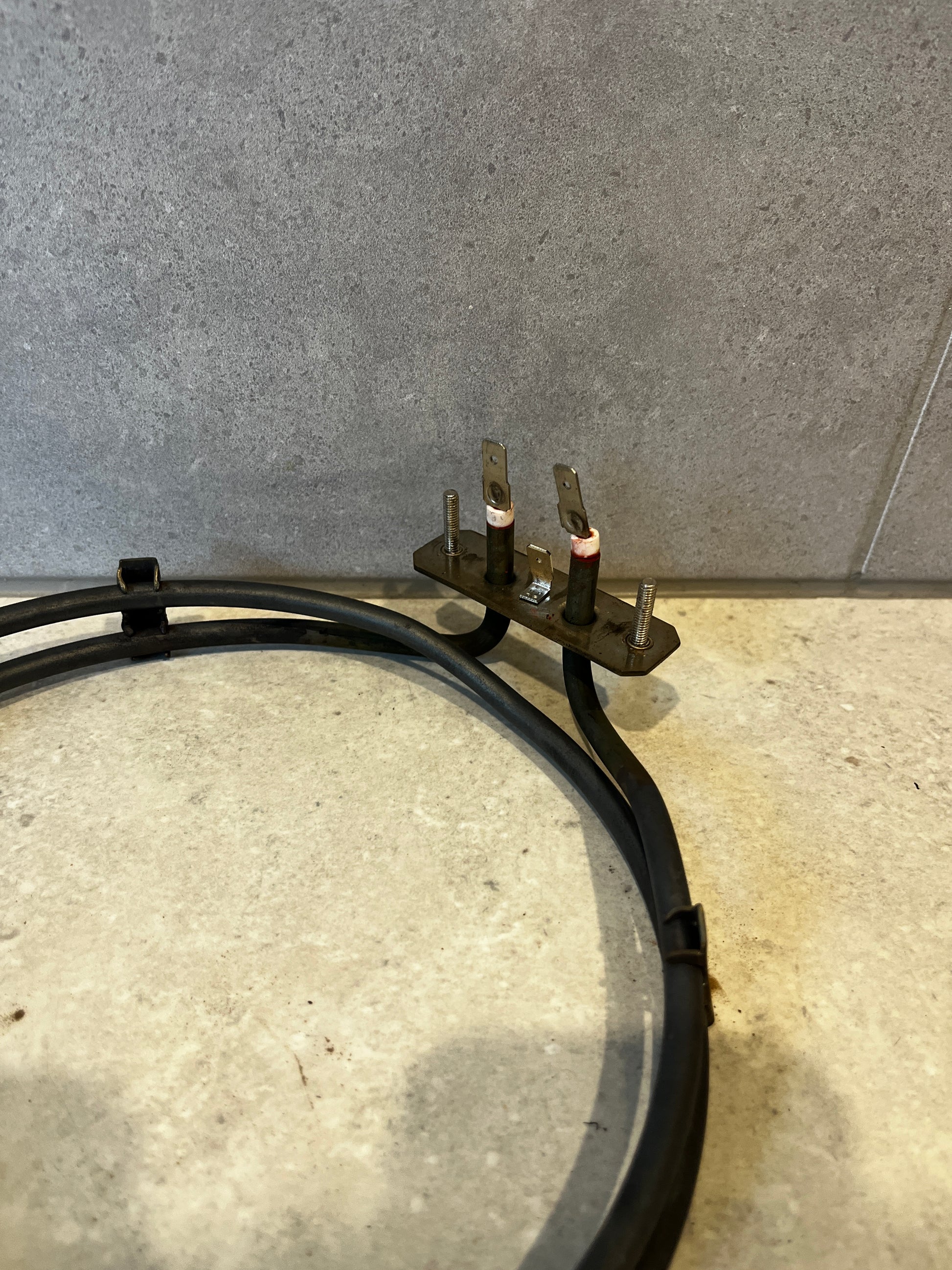 Detailed view of the heating element's two terminal connectors and mounting screws