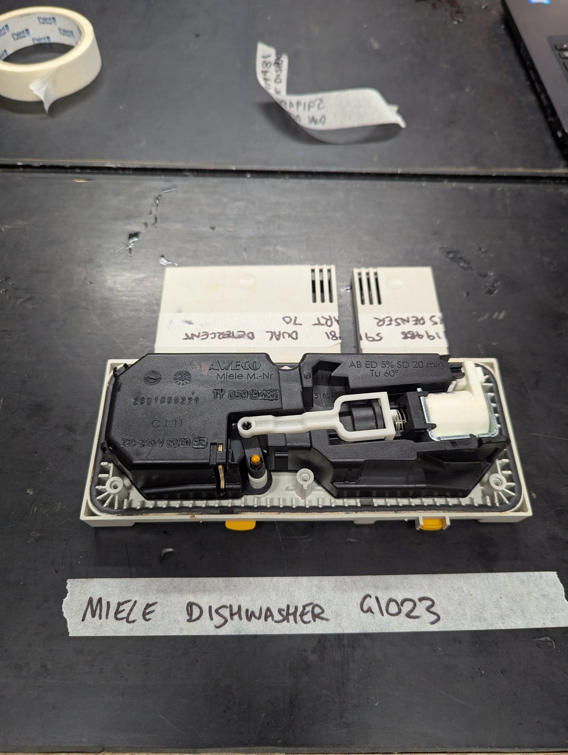 Rear view of Miele G1023 dishwasher dual detergent dispenser with internal mechanism