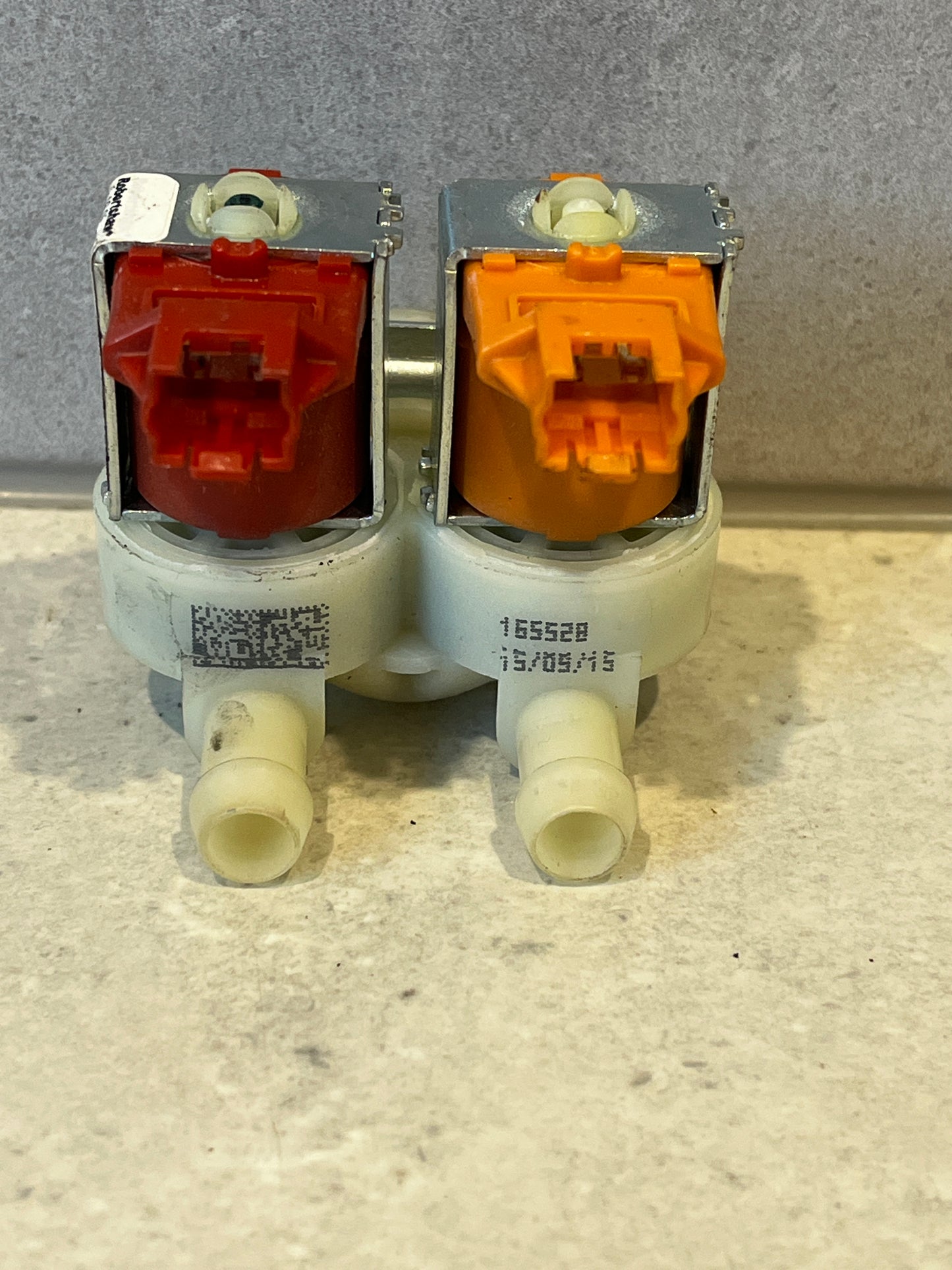 Front view of dual inlet solenoid water valve displaying inlet ports and plastic housing