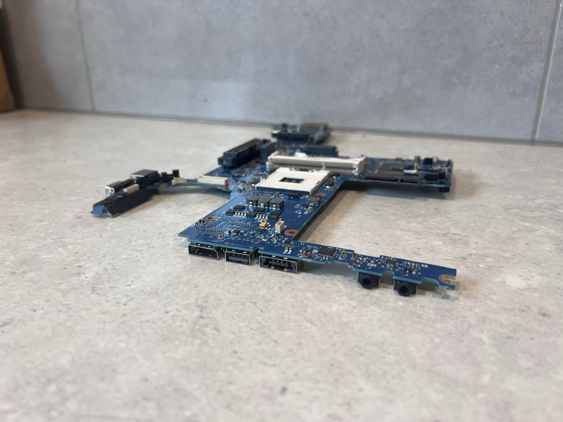 Side view highlighting I/O ports of blue laptop mainboard