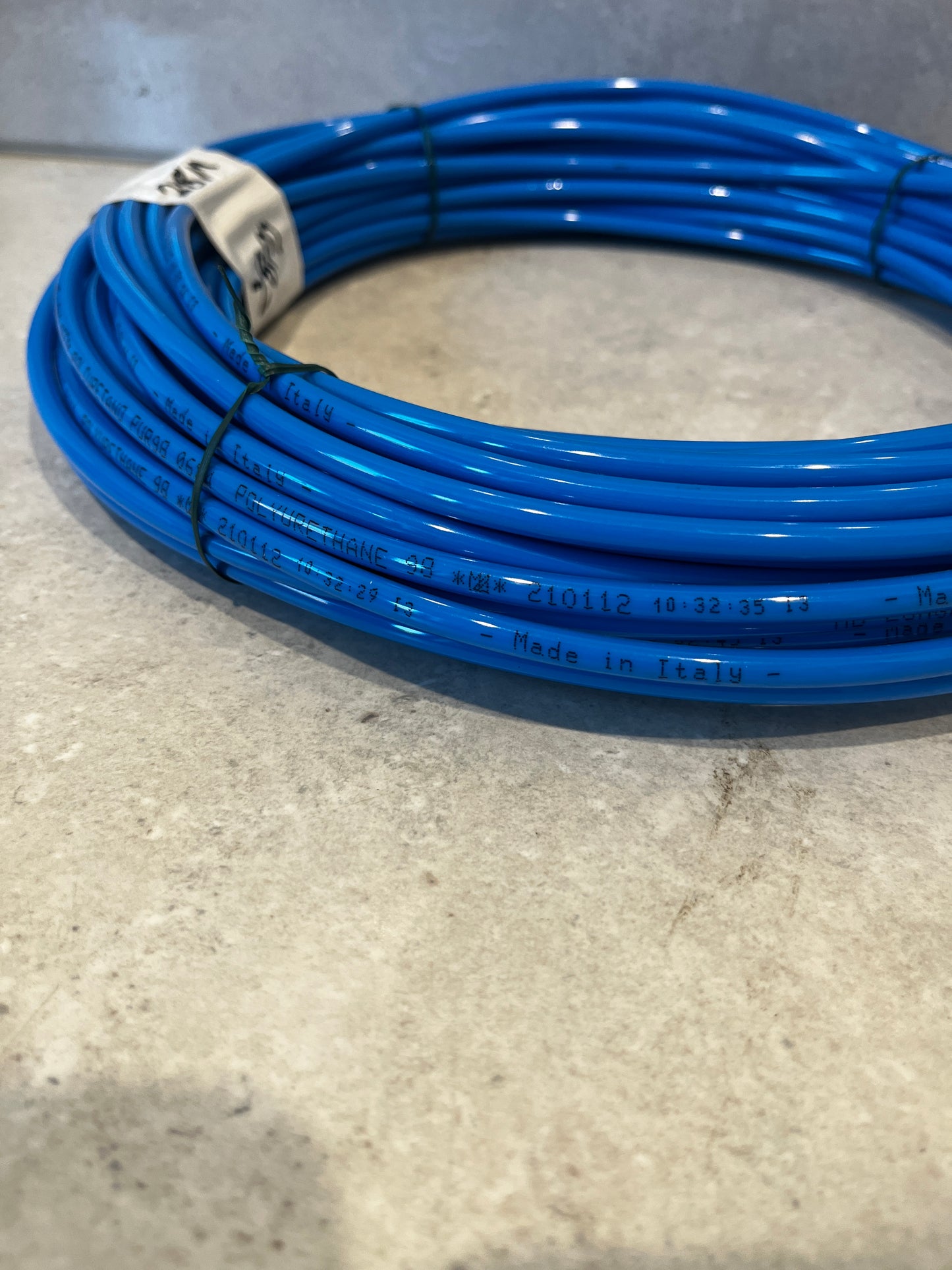 Side angle of blue polyurethane tubing coil highlighting blue flexible material and length label