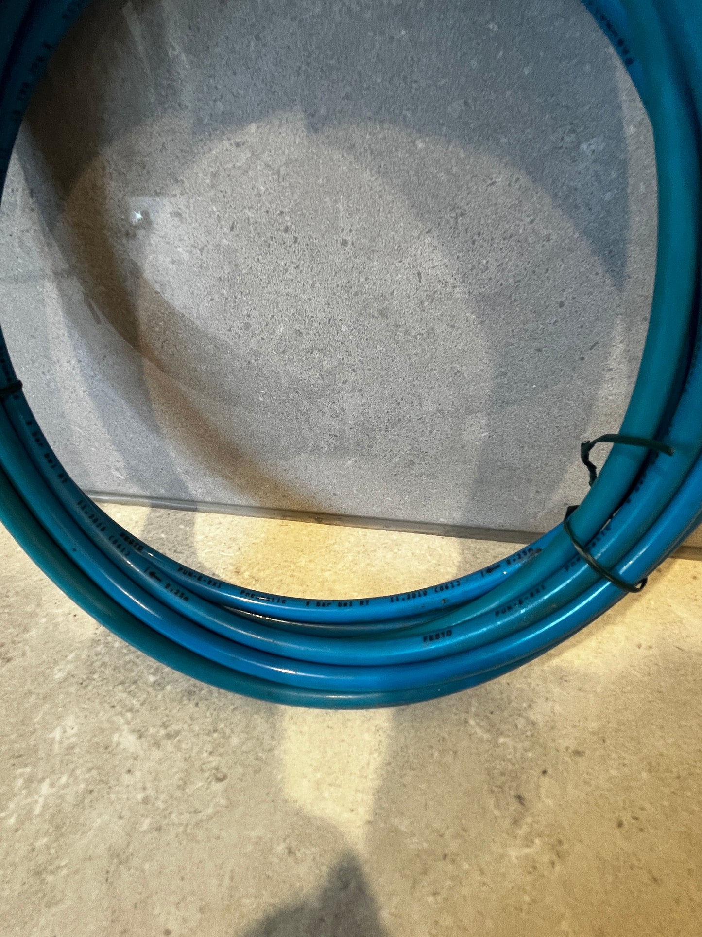 Detailed view of coiled blue pneumatic hose showing brand and pressure information