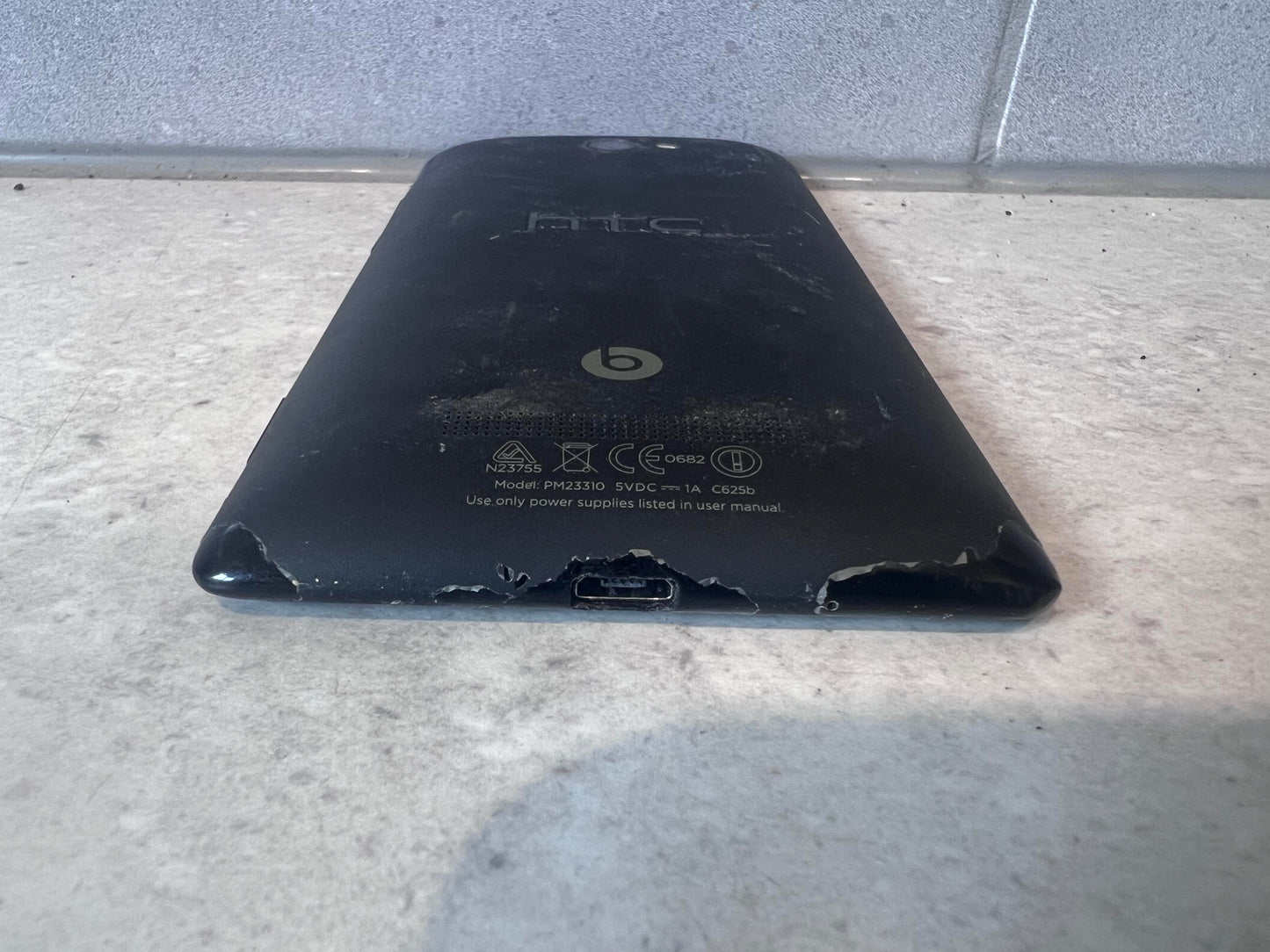 Bottom angle of HTC smartphone showing wear and charger port